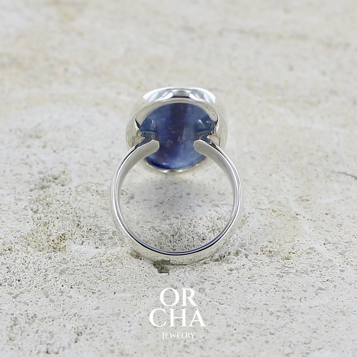 détail du dos d'une grande bague pour femme en argent massif, sertie d'un long cabochon ovale de cyanite de couleur bleu denim nacré. Pierre de qualité translucide. Bijou unique réalisée en taille 58 par Orcha jewelry