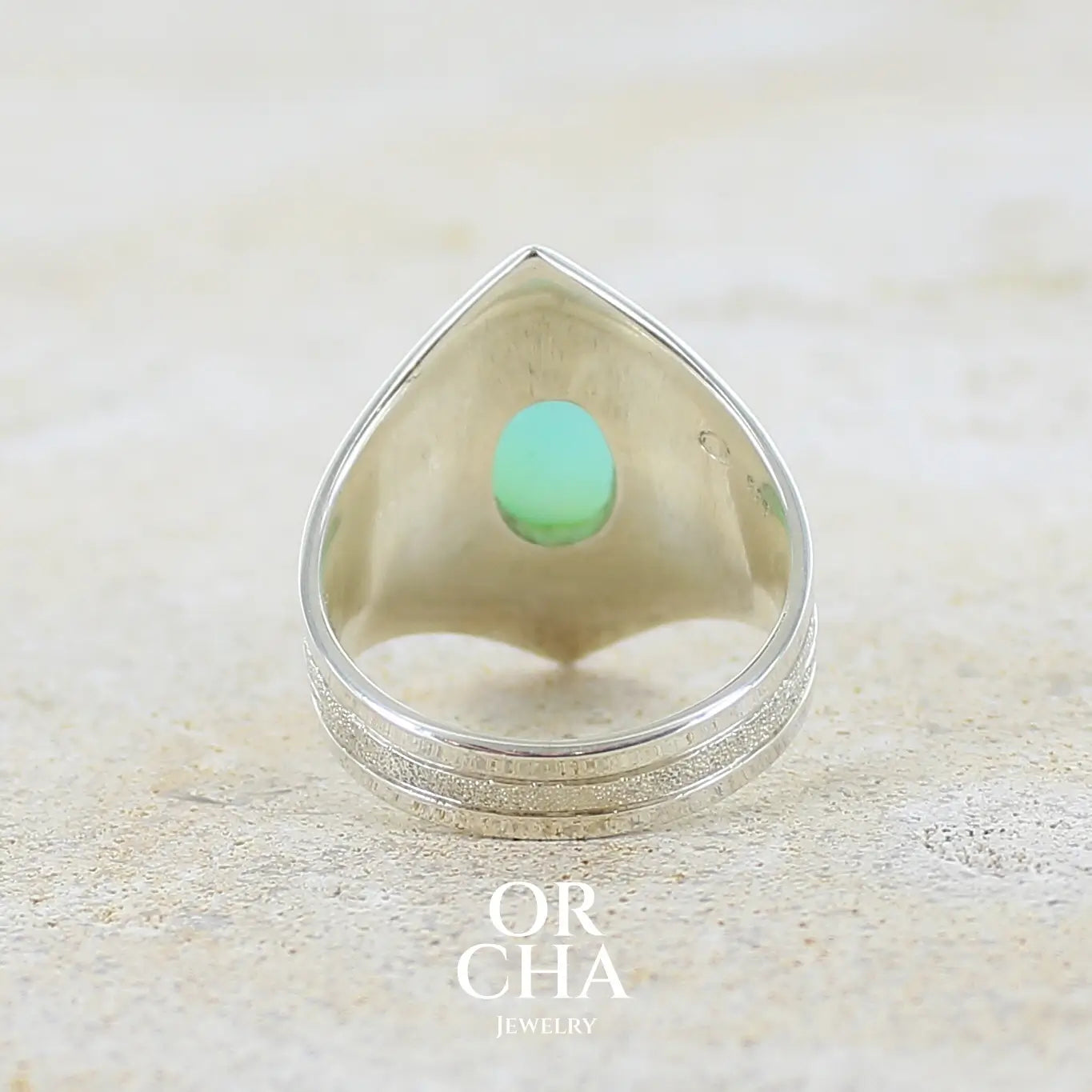Vue de dos d'une bague pour femme en argent massif, sertie d'un cabochon d'opale bleue du Pérou de couleur bleu ciel turquoise. Pierre taillée de forme ovale de qualité opaque. Bijou unique réalisé en taille 60,5.