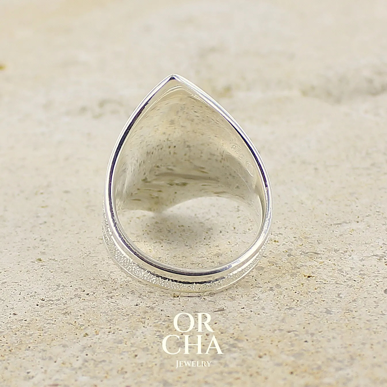 vue de dos d'une grande Bague marquise pour femme en argent massif, sertie d'un cabochon de calcédoine bleue verte. Pierre taillée de en forme de goutte. Pierre translucide. bijou unique réalisée en taille 54 par Orcha Jewelry