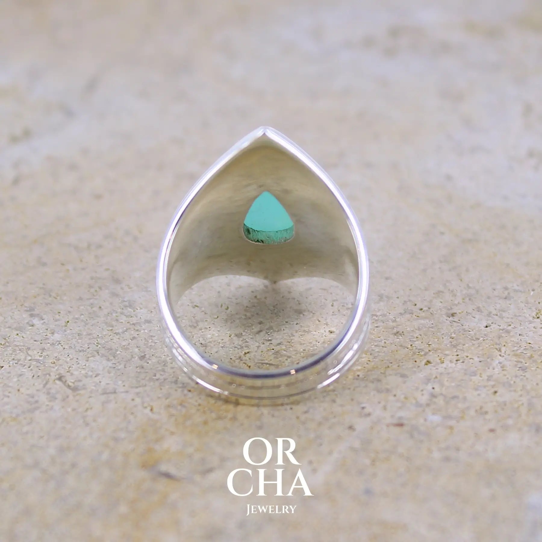 Vue de dos d'une bague pour femme en argent massif sculptées d'étoiles et autres corps célestes sertie d'une Opale bleue du Pérou. Pierre cabochon en forme de goutte, pierre naturelle de couleur bleu ciel ciel, bleu turquoise. Pierre naturelle de qualité opaque. Taille 51. Bijoux unique, éthique et durable présenté dans un coffret de notre marque, prêt à offrir. Livraison offerte, certificat d'authenticité, service client.