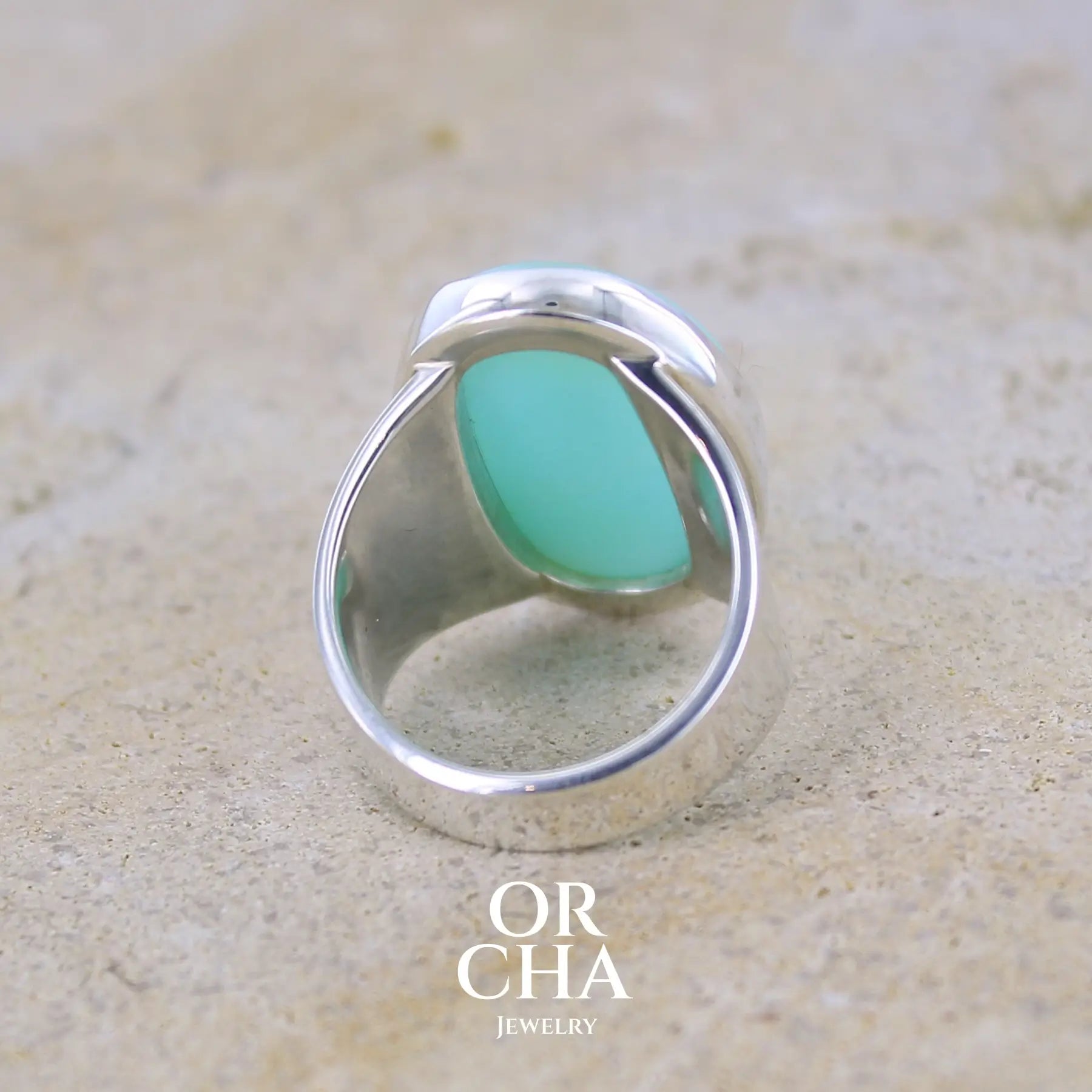 Vue de dos d'une grande Bague pour femme en argent massif, sertie d'un cabochon d'opale bleue du Pérou. Pierre taillée de forme ovale. Pierre opaque. Taille 58,5. Bijoux unique, éthique et durable présenté dans un coffret de notre marque, prêt à offrir. Livraison offerte, certificat d'authenticité, service client.
