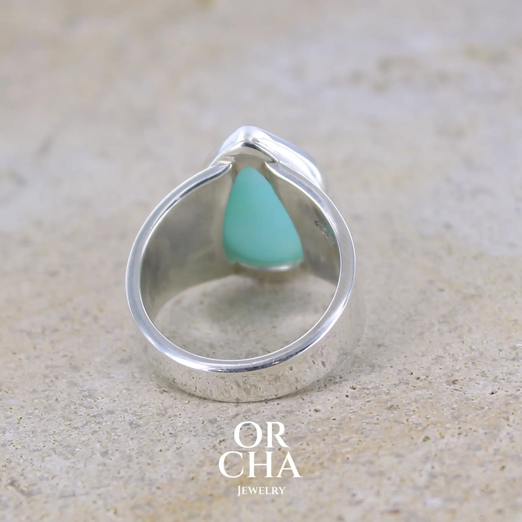 vue de dos d'une bague pour femme en argent massif sertie d'une Opale bleue du Pérou. Pierre naturelle de couleur bleu ciel, taillée en cabochon en forme de goutte, de qualité opaque. Taille 51. Bijoux unique, éthique et durable présenté dans un coffret de notre marque, prêt à offrir. Livraison offerte, certificat d'authenticité, service client.