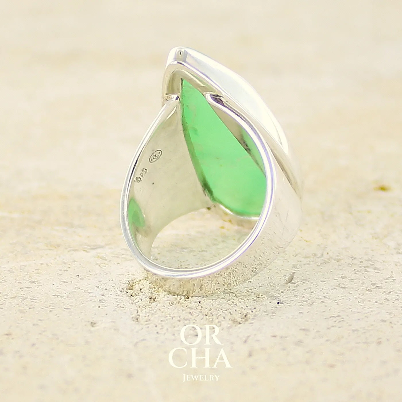 Dos d'une grande Bague pour femme en argent massif, sertie d'un cabochon de chrysoprase. Pierre naturelle de couleur verte taillée en forme de goutte de qualité translucide. Bijoux unique réalisé en taille 54 par Orchajewelry