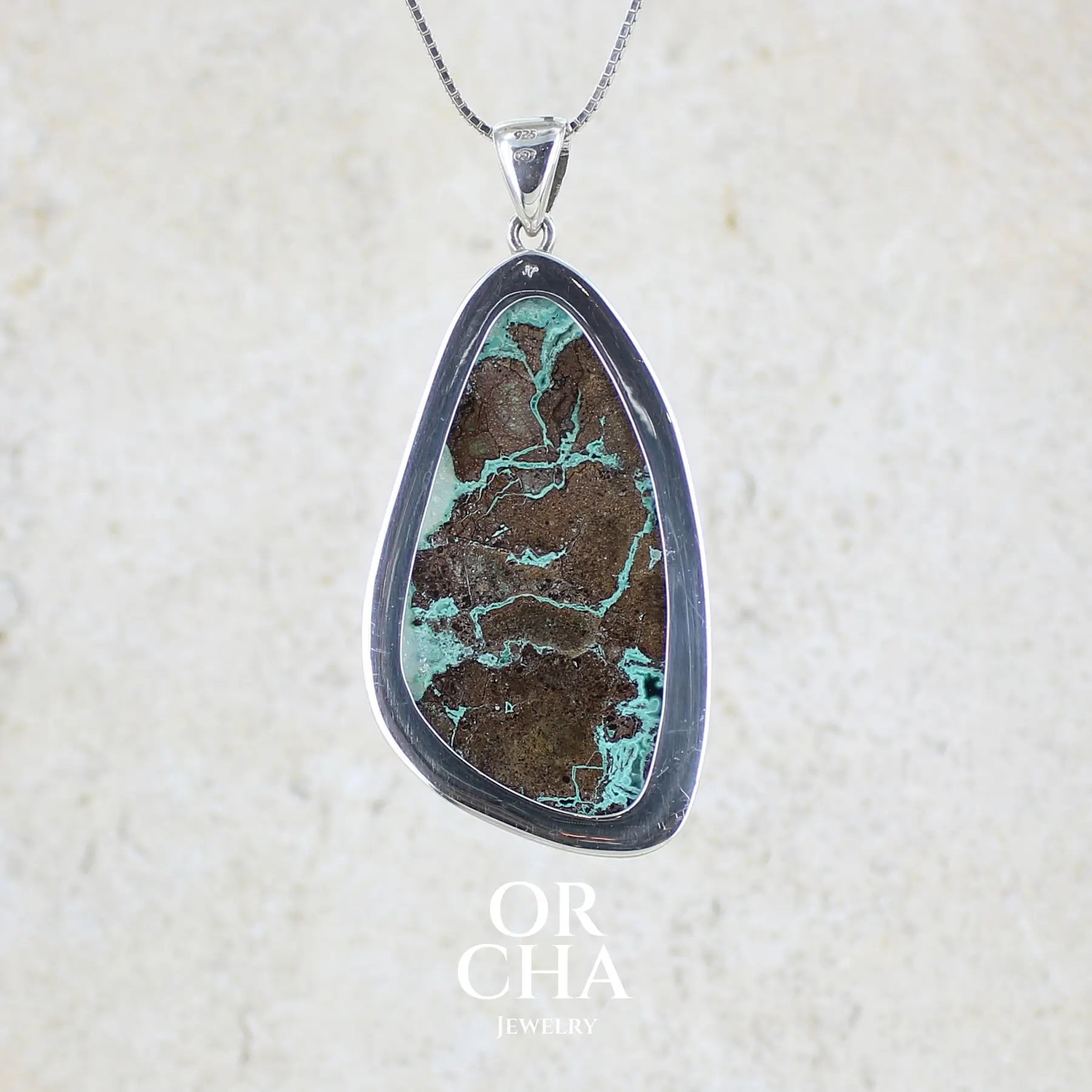 Vue de dos d'un pendentif en argent massif serti d'un magnifique gemsilica druze: chrysocolle silicifiée recouverte de fins cristaux de quartz scintillant. Pierre de qualité opaque brute en forme de goutte. Pierre naturelle originaire du Mexique de couleur bleue ciel turquoise claire.