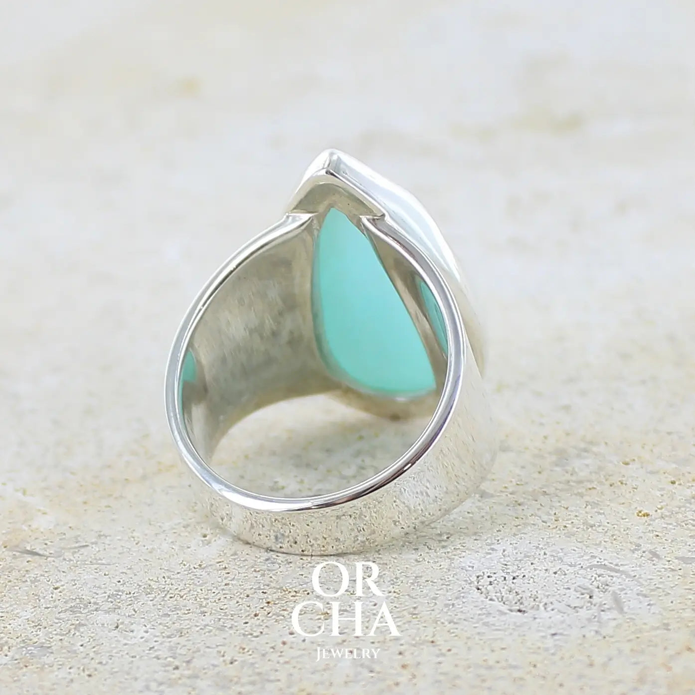 vue de dos d'une grande Bague pour femme en argent massif, sertie d'un cabochon d'opale bleue du Pérou de couleur bleu ciel. Pierre taillée en forme de goutte de qualité opaque. Bijou unique réalisé en taille 60 FR.