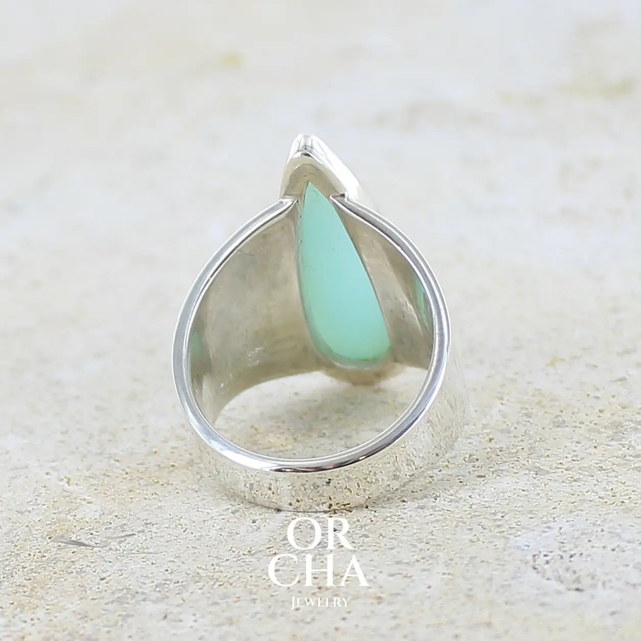 vue de dos d'une bague pour femme en argent massif, sertie d'un cabochon d'opale bleue du Pérou de couleur bleu ciel. Pierre taillée en forme de goutte longiligne, de qualité opaque. Bijou unique réalisé en taille 53,5. 