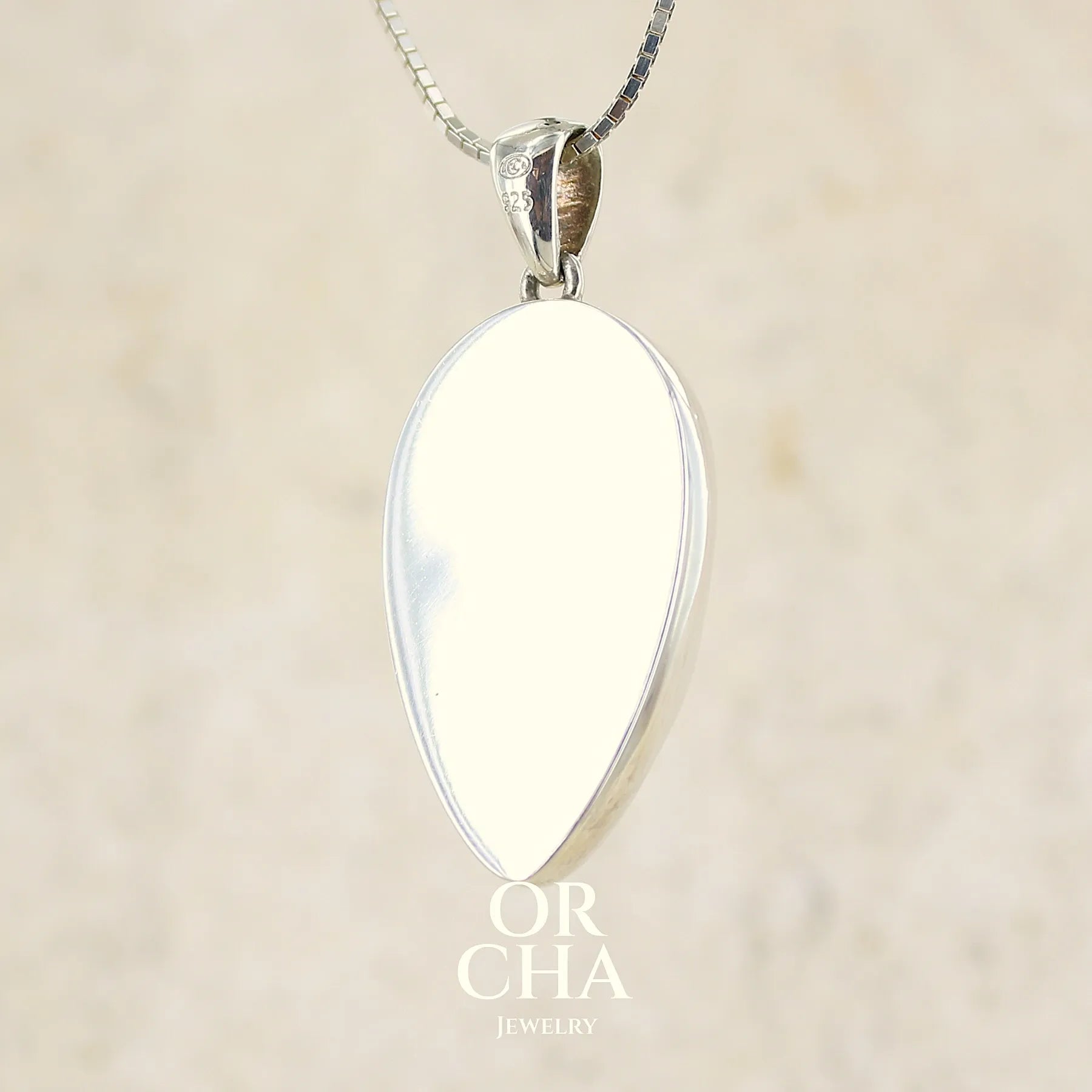 vue de dos d'un pendentif pour femme en argent massif, sertie d'un cabochon de chrysoprase de couleur vert bleuté. Pierre de qualité translucide taillée en forme de goutte. Bijoux unique par Orcha jewelry