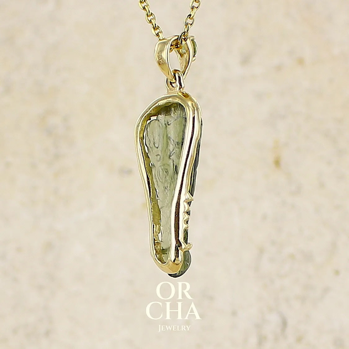 vue de dos d'un pendentif pour homme en or 18k serti d'une moldavite sculptée en tête de crocodile. Pierre naturelle de couleur verte kaki translucide. Bijoux unique par Orcha jewelry