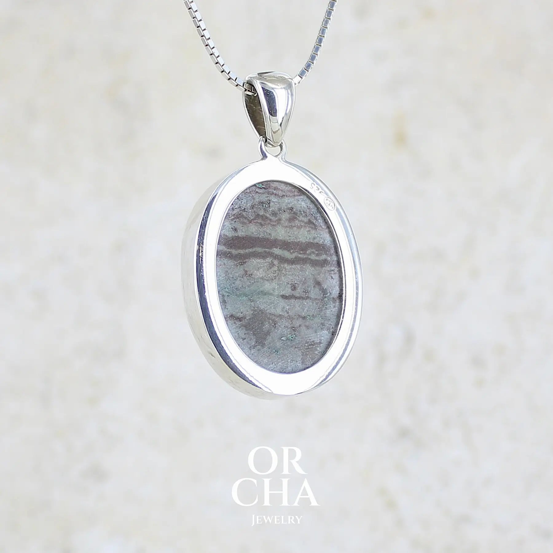 vue de dos d'un pendentif pour femme en argent massif sertie d'un magnifique gemsilica druzy, chrysocolle silicifiée recouverte de fins cristaux de quartz scintillant. Pierre de qualité opaque taillée en tranche de forme ovale. Pierre naturelle originaire de République dominicaine du Congo de couleur bleu clair turquoise. pierre rare et unique

