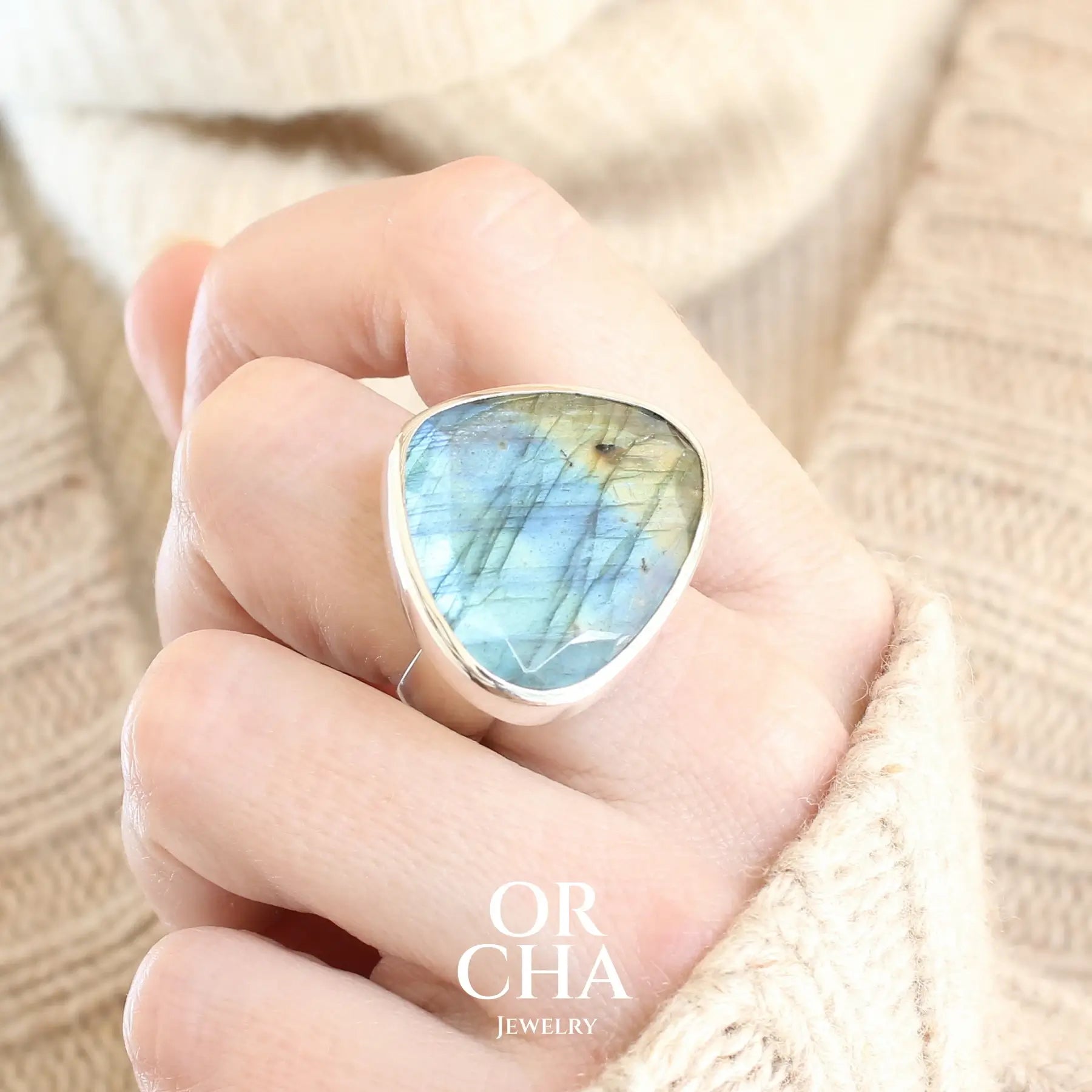 Bague pour femme en argent massif sertie d'une labradorite aux reflets bleus et verts selon la lumière. Pierre facettée naturelle translucide présentant des inclusions fréquents sur ce type de pierre. Taille 56. Bijoux unique, éthique et durable présenté dans un coffret de notre marque, prêt à offrir. Livraison offerte, certificat d'authenticité, service client.