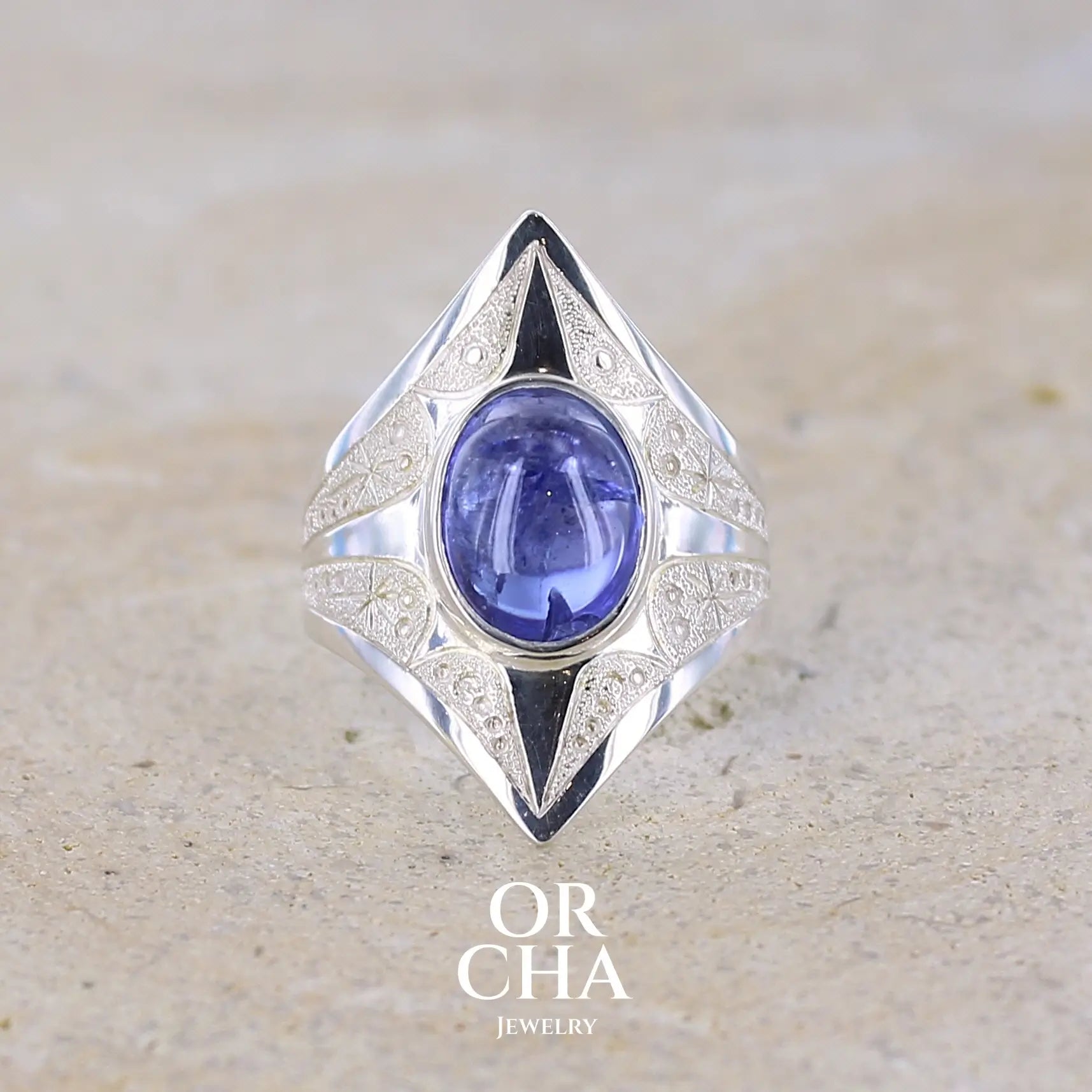 Grande Bague pour femme en argent massif, sertie d'un cabochon de tanzanite bleu lavande. Pierre taillée de forme ovale. Pierre transparente comportant des inclusions. Taille 59. Bijoux unique, éthique et durable présenté dans un coffret de notre marque, prêt à offrir. Livraison offerte, certificat d'authenticité, service client.