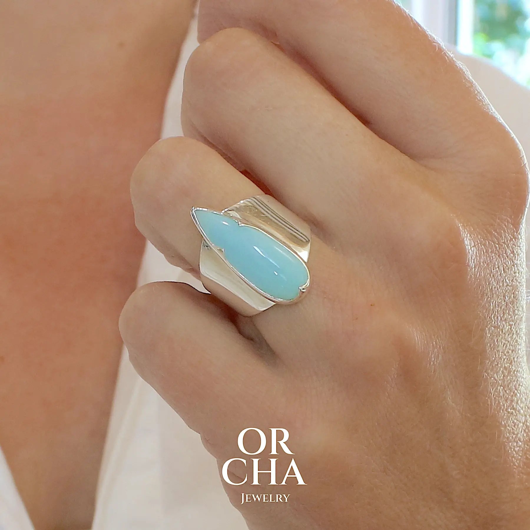 Bague pour femme en argent massif, sertie d'un cabochon d'opale bleue du Pérou de couleur bleu ciel. Pierre taillée en forme de goutte longiligne, de qualité opaque. Bijou unique réalisé en taille 53,5. 