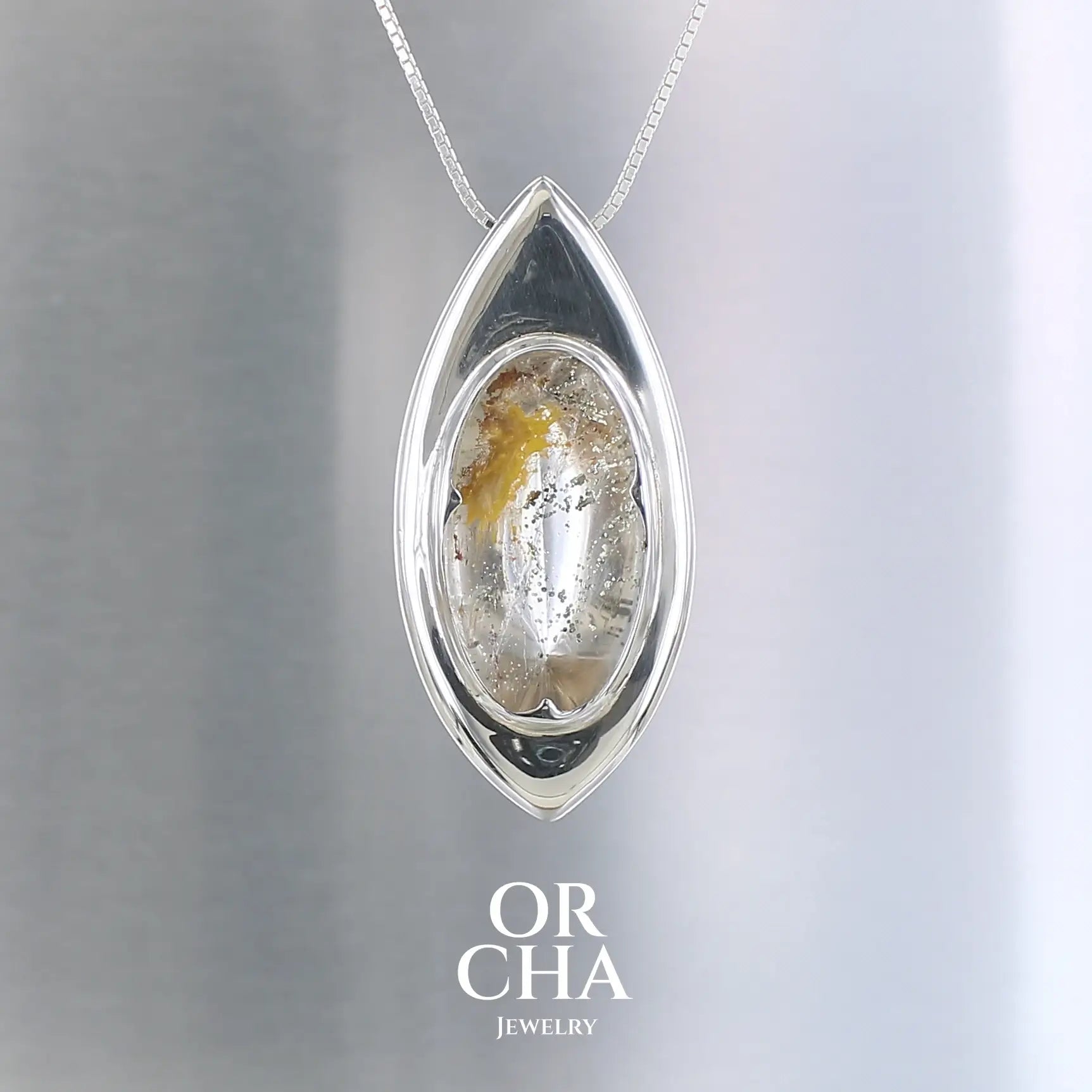 Pendentif de créateur, original et contemporain, pour femme, en argent massif serti d'un Quartz à inclusions de Marcassite doré. Bijoux unique, éthique et durable présenté dans un coffret de notre marque, prêt à offrir. Livraison offerte, certificat d'authenticité, service client.
