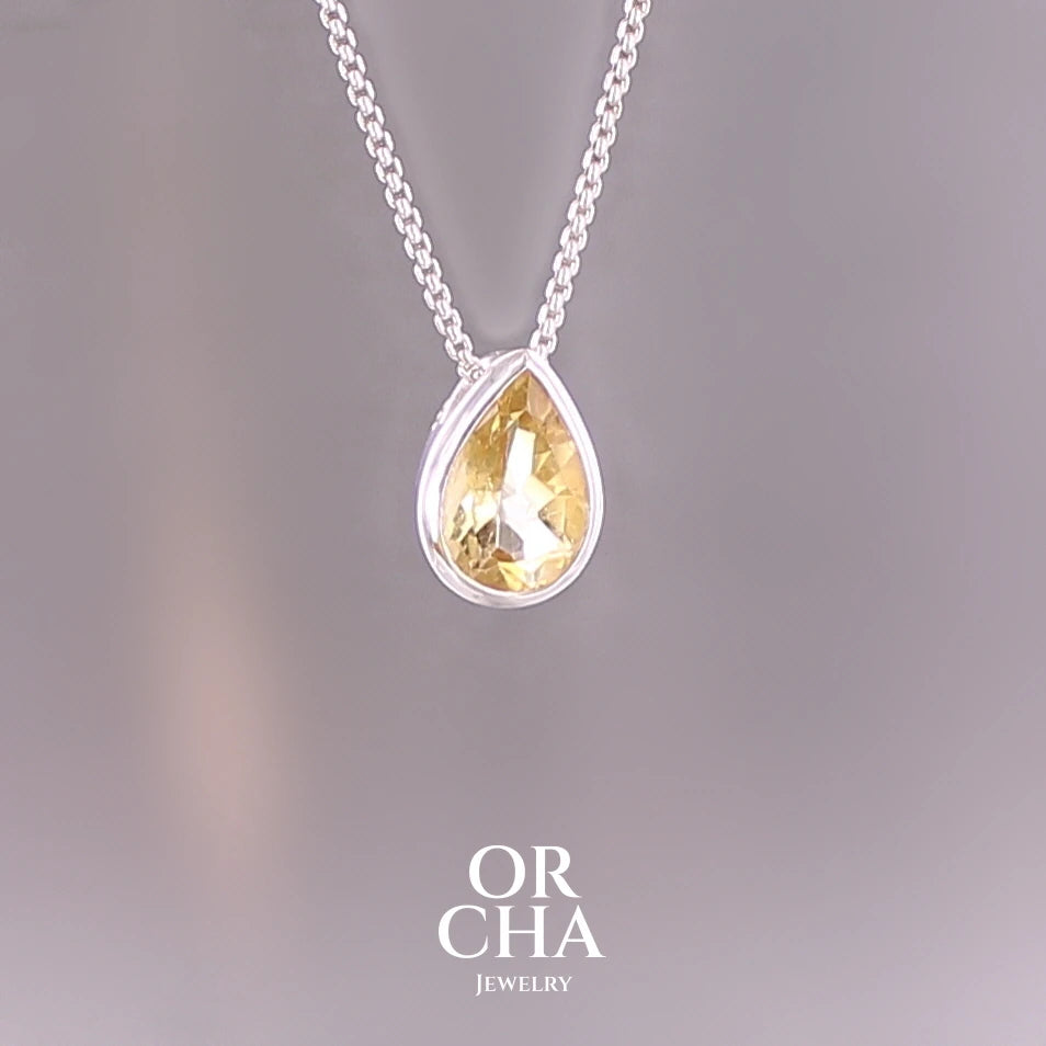 Collier solitaire pour femme en argent massif serti d'une Citrine. Pierre au nuance de couleur jaune doré lumineux, pierre facettée en forme de goutte, qualité transparente propre à l'oeil. Pendentif monté sur une chaine en argent sterling de type maille vénitienne de 1,3 mm d'épaisseur et de 40 cm de longueur. Bijoux unique, éthique et durable présenté dans un coffret de notre marque, prêt à offrir. Livraison offerte, certificat d'authenticité, service client. Par Orcha Jewelry