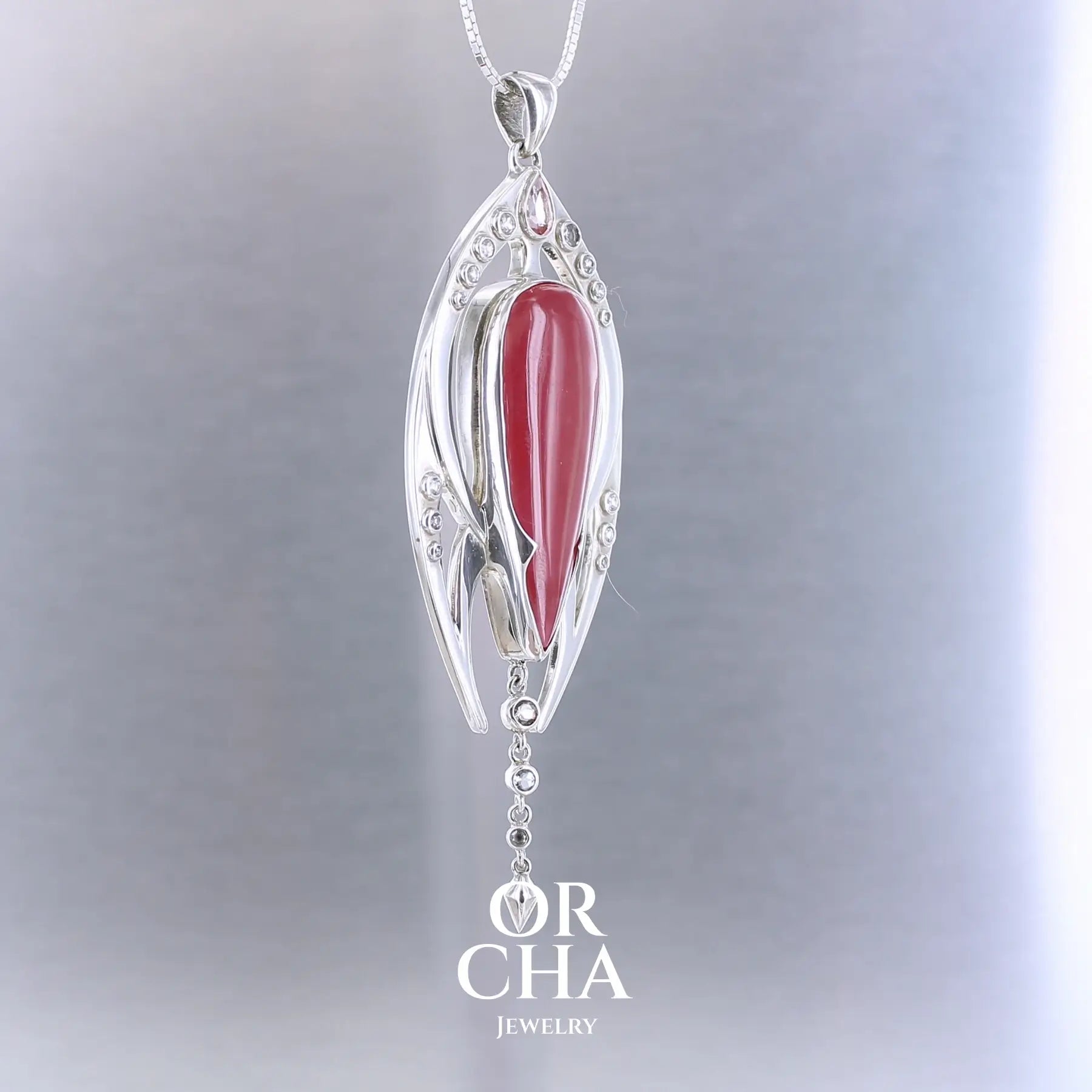 Pendentif exclusif, création originale, pour femme en argent massif serti d'une Rhodonite de très belle qualité, d'une tourmaline et de goshénite. Pierre de couleur rouge coquelicot, rose pastel et blanche, translucide à transparentes. Pierre naturelle, en forme de goutte, taillée en cabochon. Bijoux unique, éthique et durable présenté dans un coffret de notre marque, prêt à offrir. Livraison offerte, certificat d'authenticité, service client