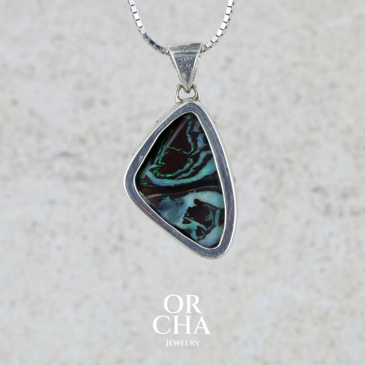 Pendentif pour femme en or 9k massif et argent massif 925 serti d'une opale boulder aux feux multicolores à dominantes bleu turquoise et vert et de six diamants. Pierre cabochon de qualité opaque taillée en forme d'aile. Bijou unique par Orchajewelry