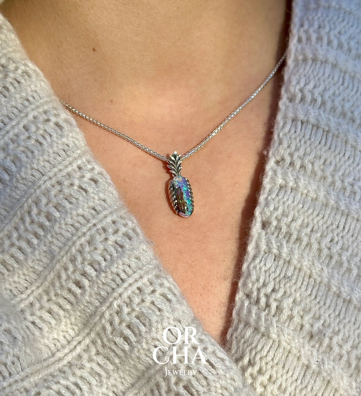Pendentif pour femme en argent massif 925 serti d'une opale cristal aux feux étoilés multicolores à dominante bleu violet et vert. Cabochon de 3,2 carats taillé de forme oval de qualité transparente. Bijou unique réalisé par Orchajewelry