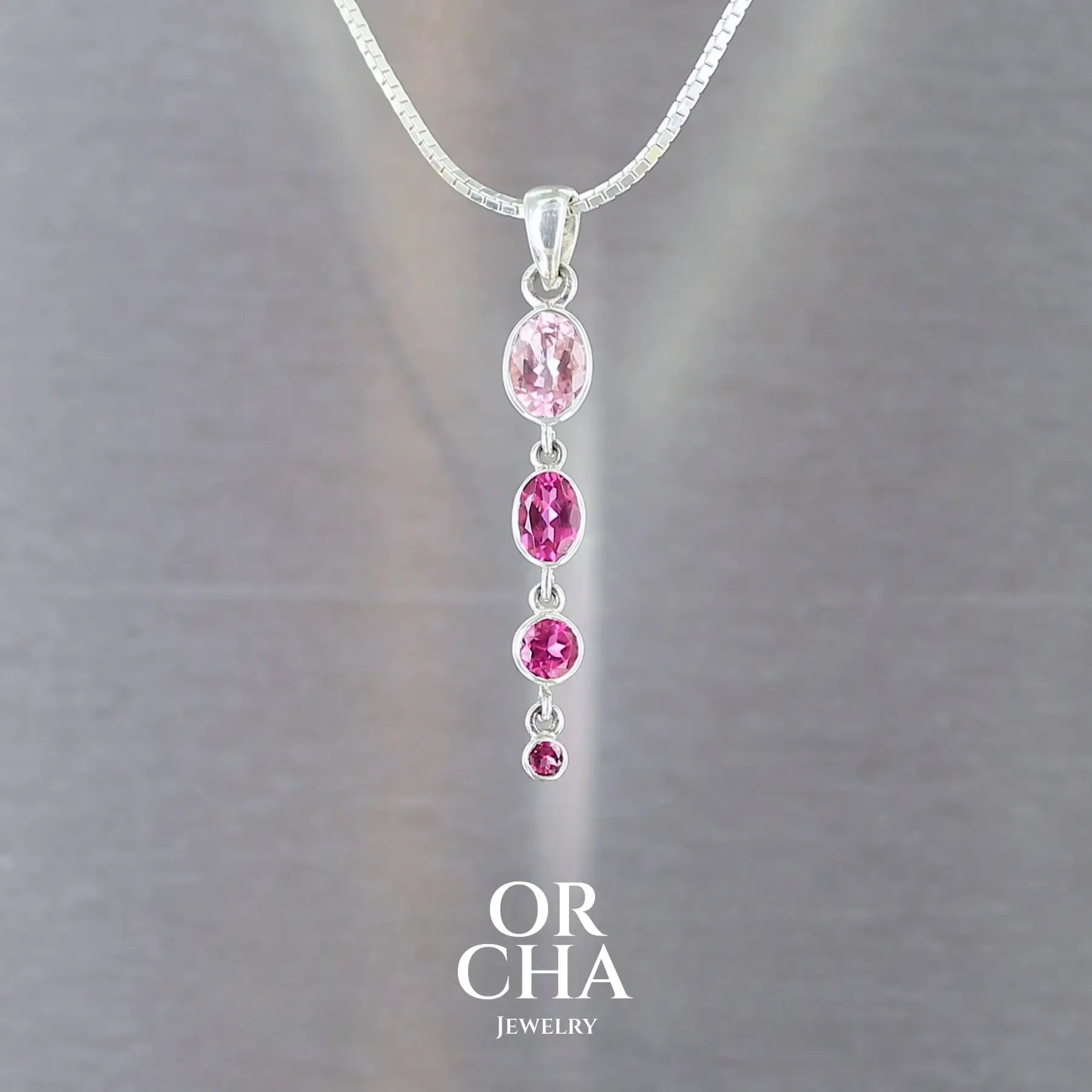 pendentif pour femme en argent massif serti en ligne de 4 tourmalines roses fuchsia et rose bonbon. Pierres facettées  transparentes propre à l'oeil.  Bijoux unique, éthique et durable présenté dans un coffret de notre marque, prêt à offrir. Livraison offerte, certificat d'authenticité, service client.