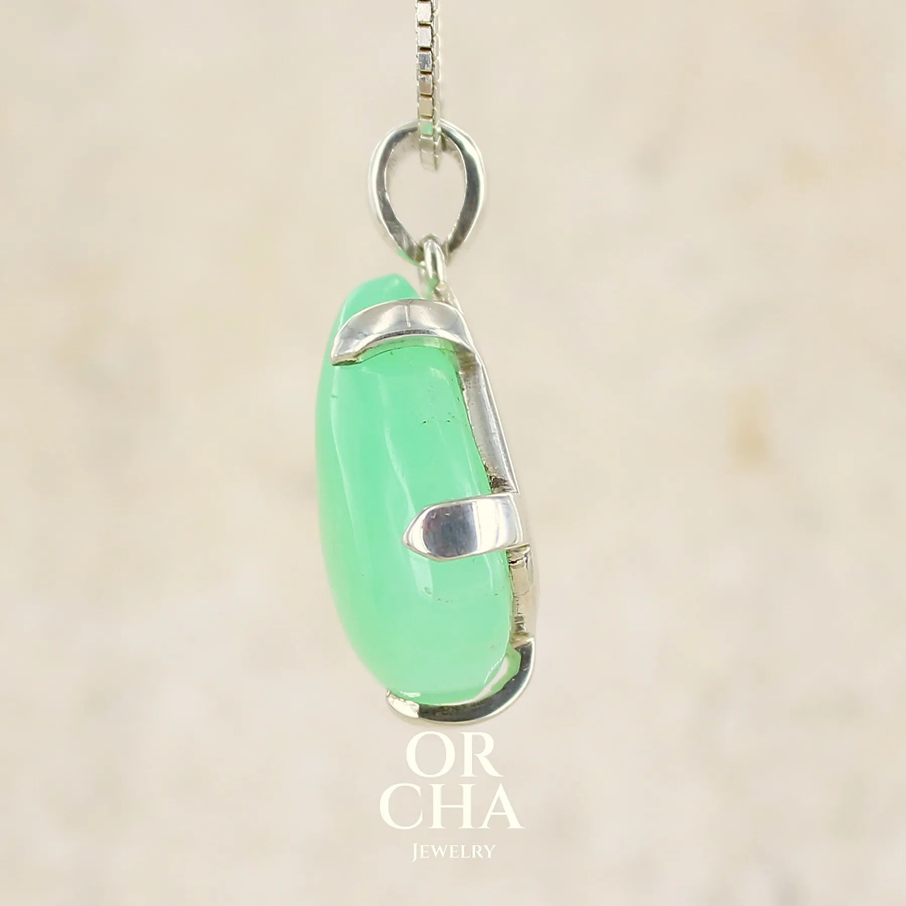 Profil d'un pendentif pour en argent massif, sertie d'un cabochon de chrysoprase de couleur verte claire. Pierre de qualité translucide taillée en cabochon en forme de goutte. Bijoux unique par Orcha jewelry