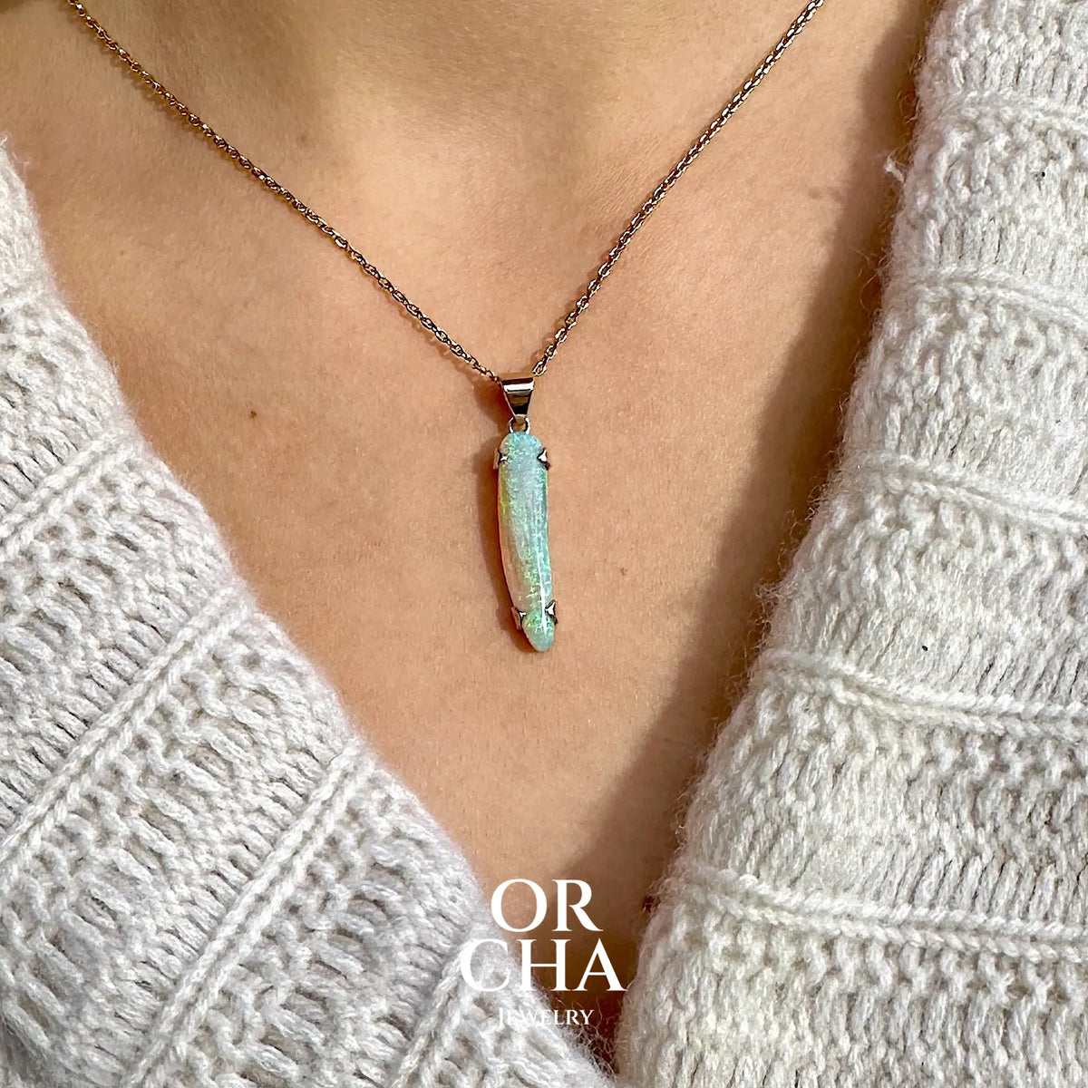 Pendentif pour femme en or jaune massif 18k serti d'une opale cristal aux feux étoilés multicolores à dominantes vert et jaune. Cabochon de 1 carat taille en forme de goutte de qualité transparente. Opale australienne de Mintabie. Bijou unique réalisé par Orchajewelry
