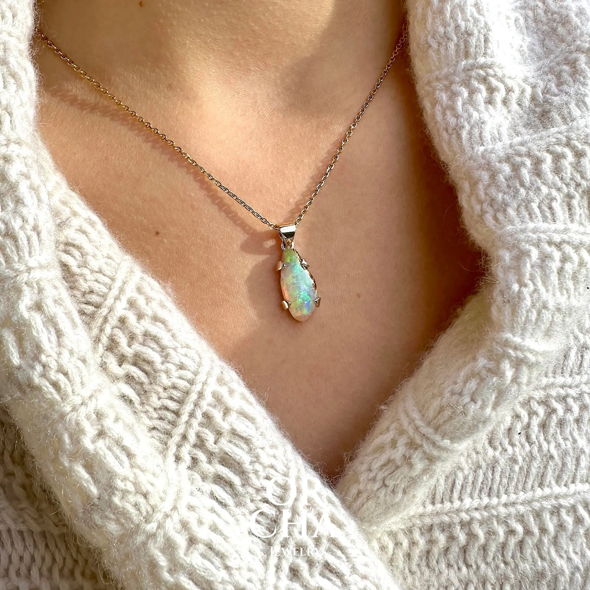 Pendentif pour femme en or 9k et argent massif 925 serti d'une opale cristal aux feux étoilés multicolores à dominantes vert et jaune. Cabochon de 3,3 carats de forme libre et de qualité translucide avec présence de roche mère. Bijou unique réalisé par Orchajewelry
