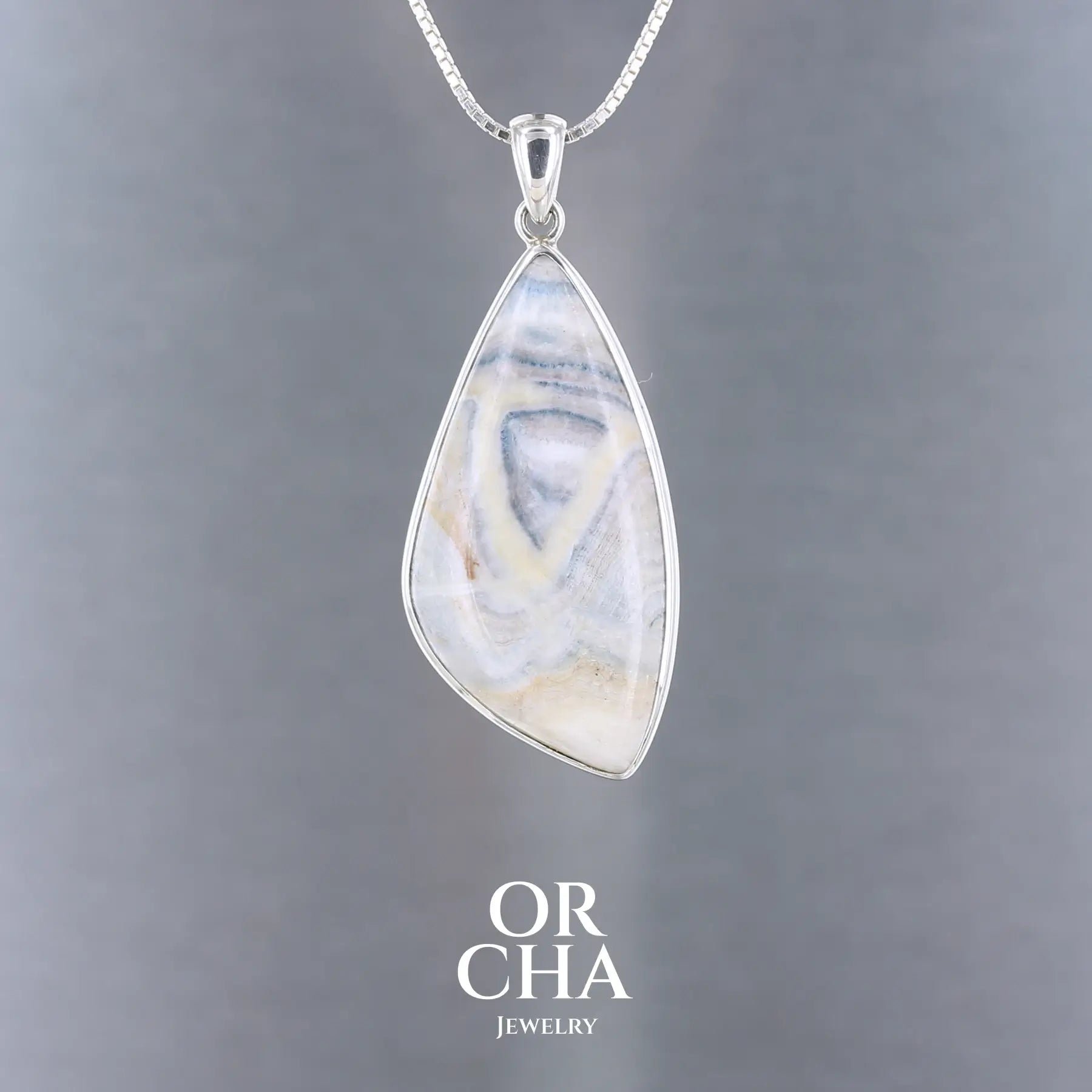 Pendentif  pour femme en argent massif sertie d'une scheelite bleue. Pierre naturelle de couleur bleu, beige crème et blanc de qualité  opaque. Bijoux unique, éthique et durable présenté dans un coffret de notre marque, prêt à offrir. Livraison offerte, certificat d'authenticité, service client.