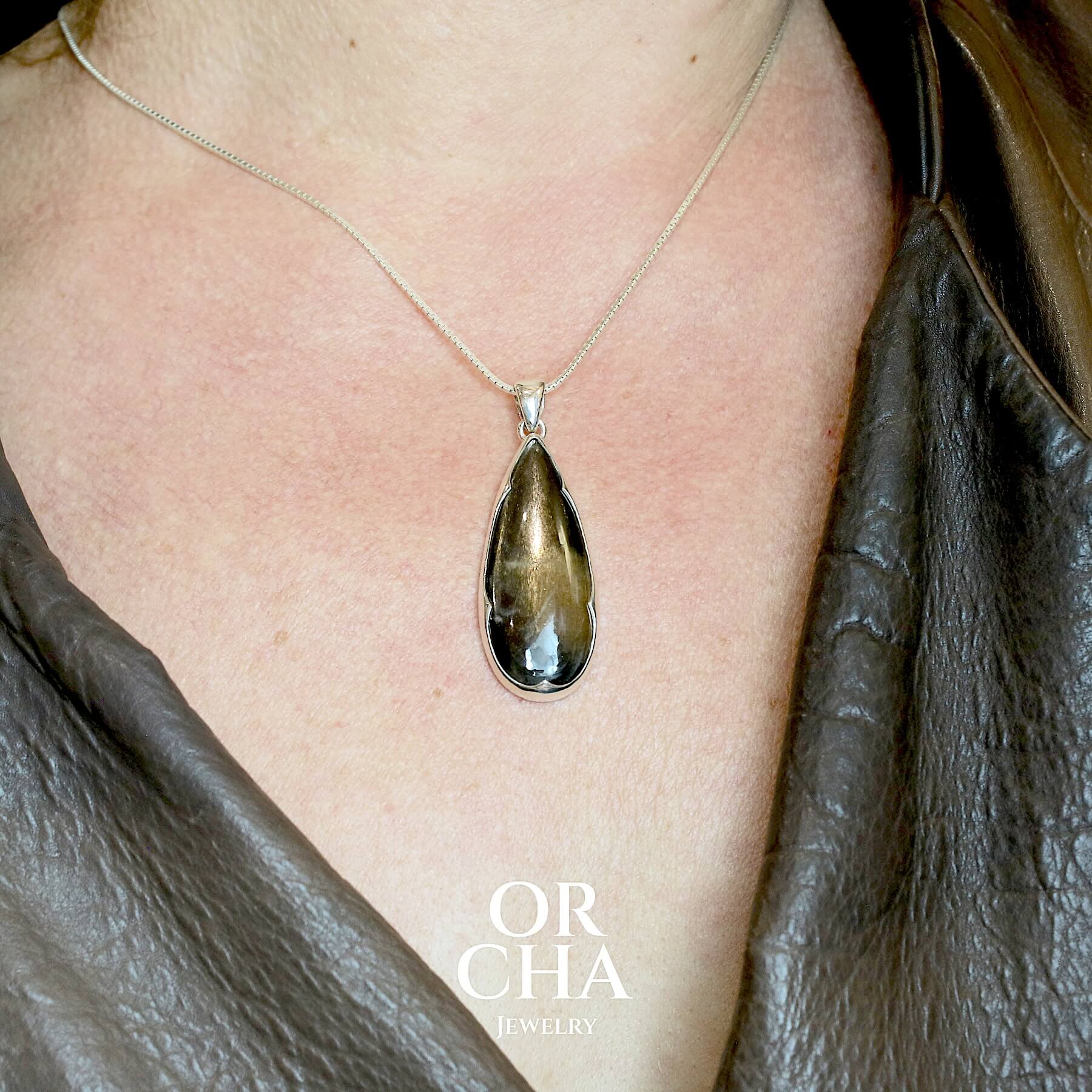 Pendentif en argent massif serti d'une pierre de soleil noire. Pierre naturelle de couleur noire à reflet argentés dorés. Bijoux unique, éthique et durable présenté dans un coffret de notre marque, prêt à offrir. Livraison offerte, certificat d'authenticité, service client.