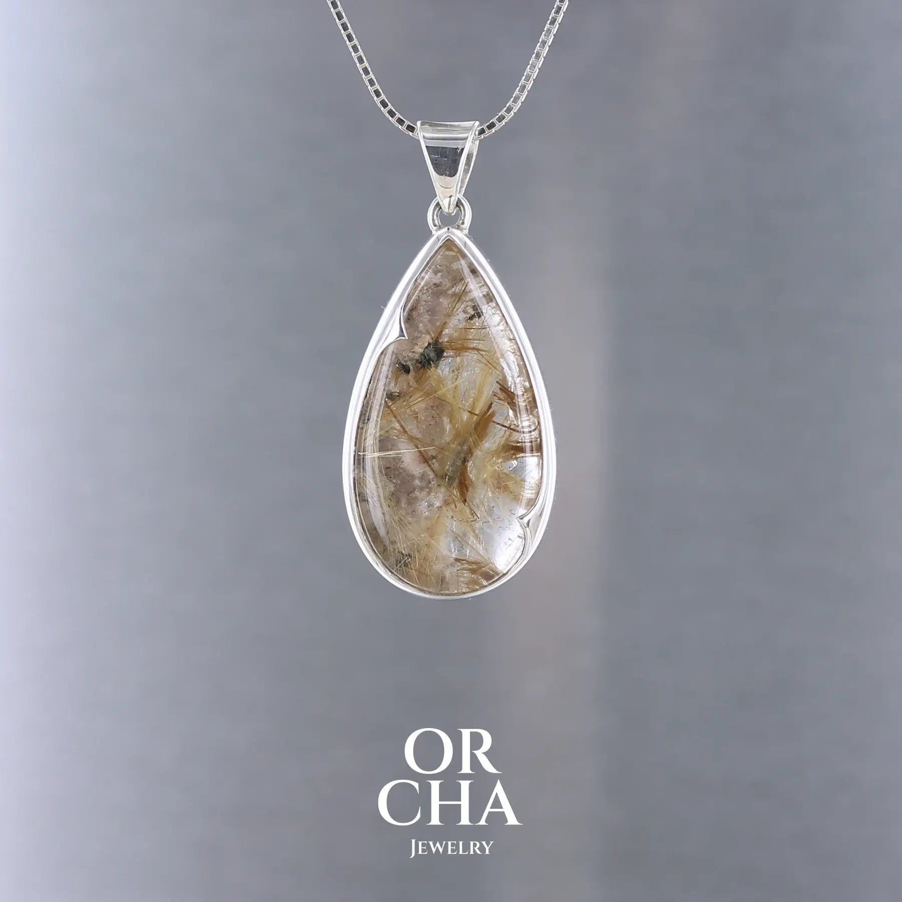 Pendentif en quartz rutile doré, monté en argent massif 925 avec un serti clos à pointe.
Une création au design affirmé, sculptée pour révéler l’éclat des inclusions dorées qui parcourent la pierre comme une pluie figée de lumière. Bijoux unique, éthique et durable présenté dans un coffret de notre marque, prêt à offrir. Livraison offerte, certificat d'authenticité, service client.
