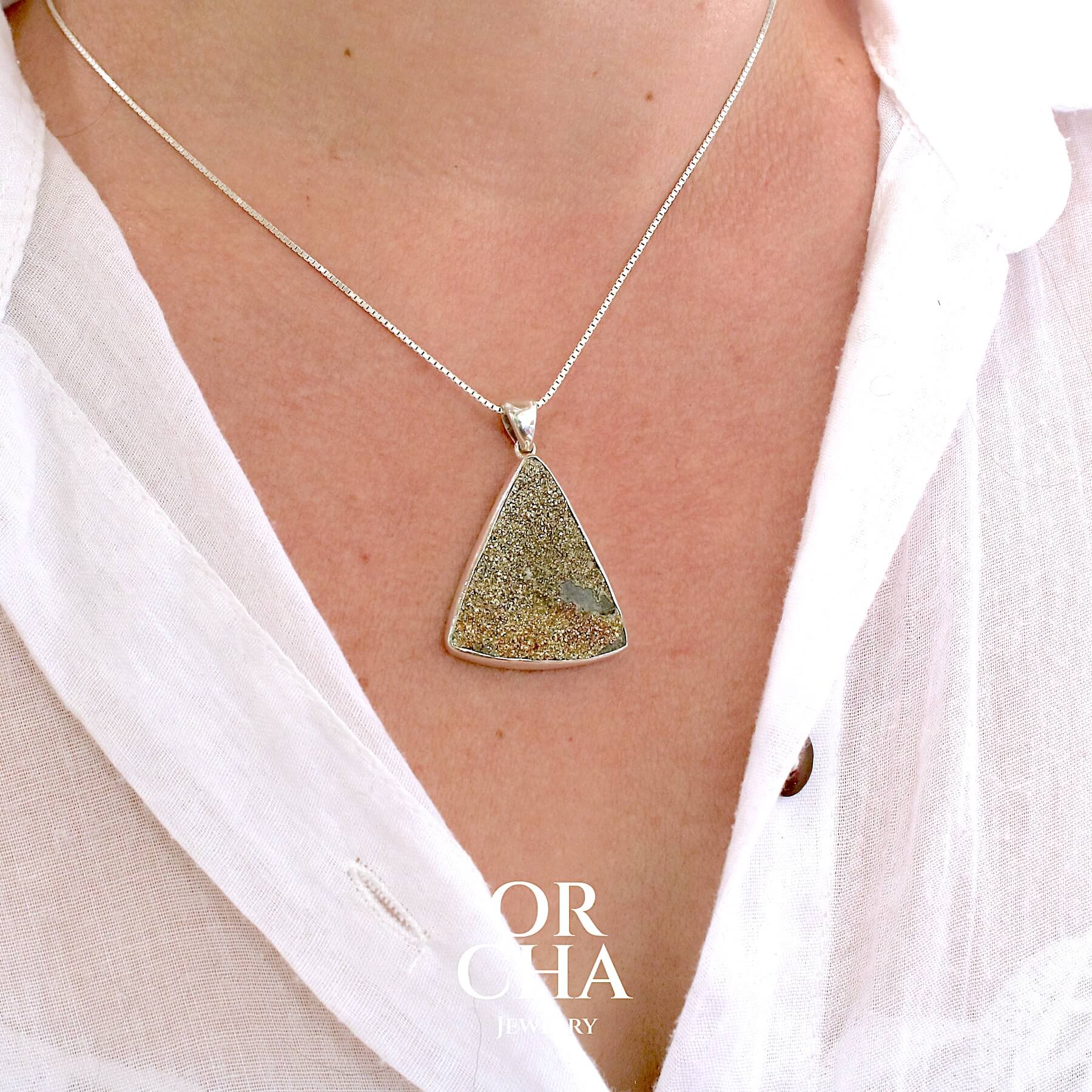 Pendentif en argent massif serti d'une pyrite brute avec ses cristaux. Pierre naturelle de couleur doré, scintillante. Bijoux unique, éthique et durable présenté dans un coffret de notre marque, prêt à offrir. Livraison offerte, certificat d'authenticité, service client.