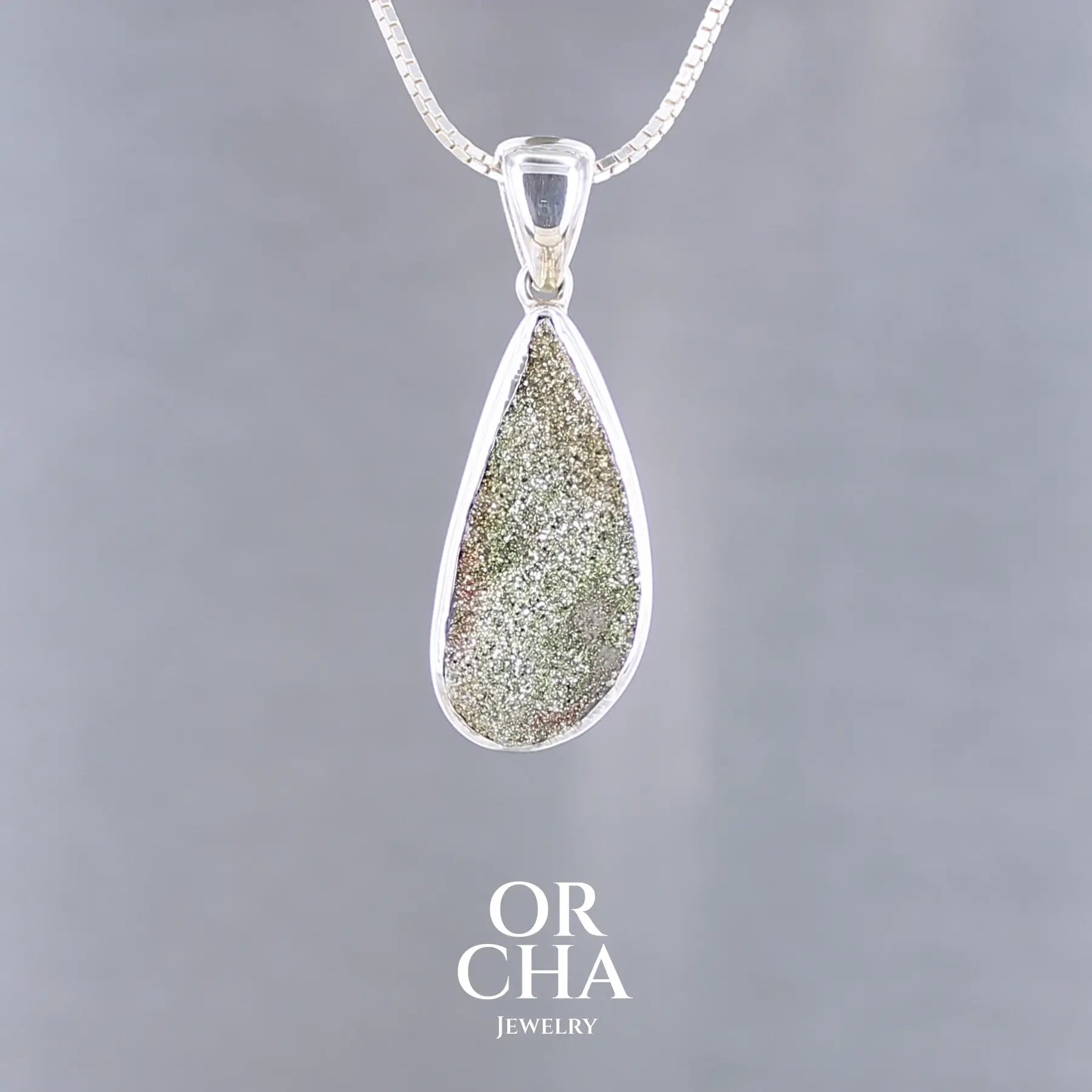 Pendentif goutte en argent massif serti d'une pyrite brute avec ses cristaux. Pierre naturelle de couleur doré, scintillante. Bijoux unique, éthique et durable présenté dans un coffret de notre marque, prêt à offrir. Livraison offerte, certificat d'authenticité, service client.