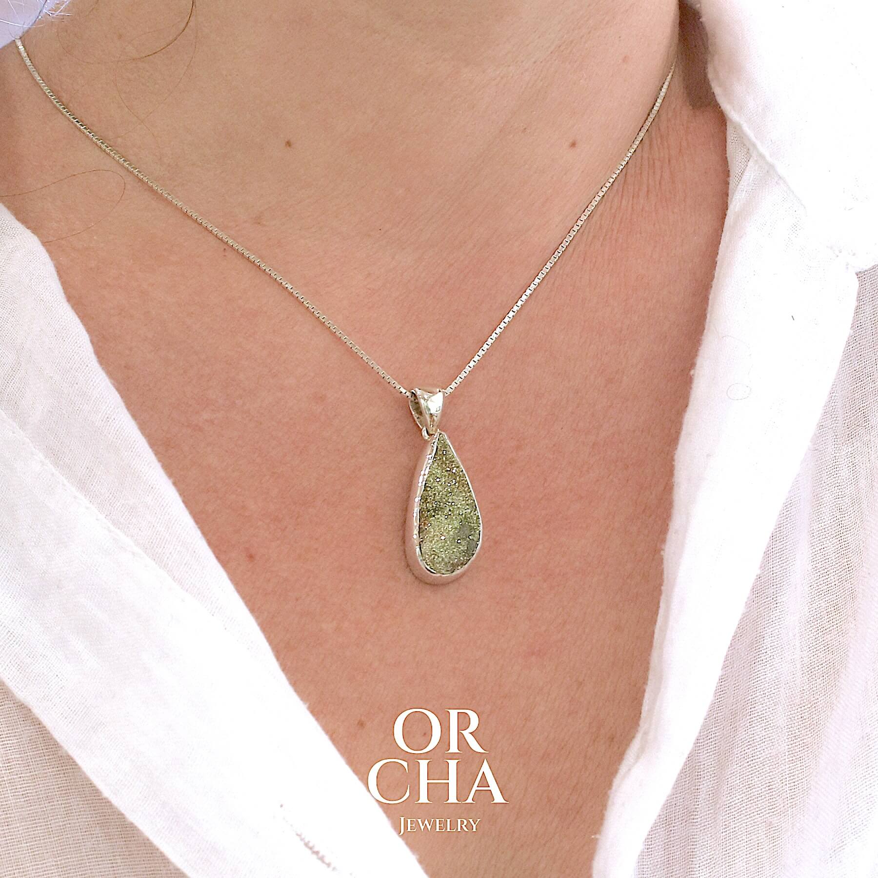 Pendentif goutte en argent massif serti d'une pyrite brute avec ses cristaux. Pierre naturelle de couleur doré, scintillante. Bijoux unique, éthique et durable présenté dans un coffret de notre marque, prêt à offrir. Livraison offerte, certificat d'authenticité, service client.
