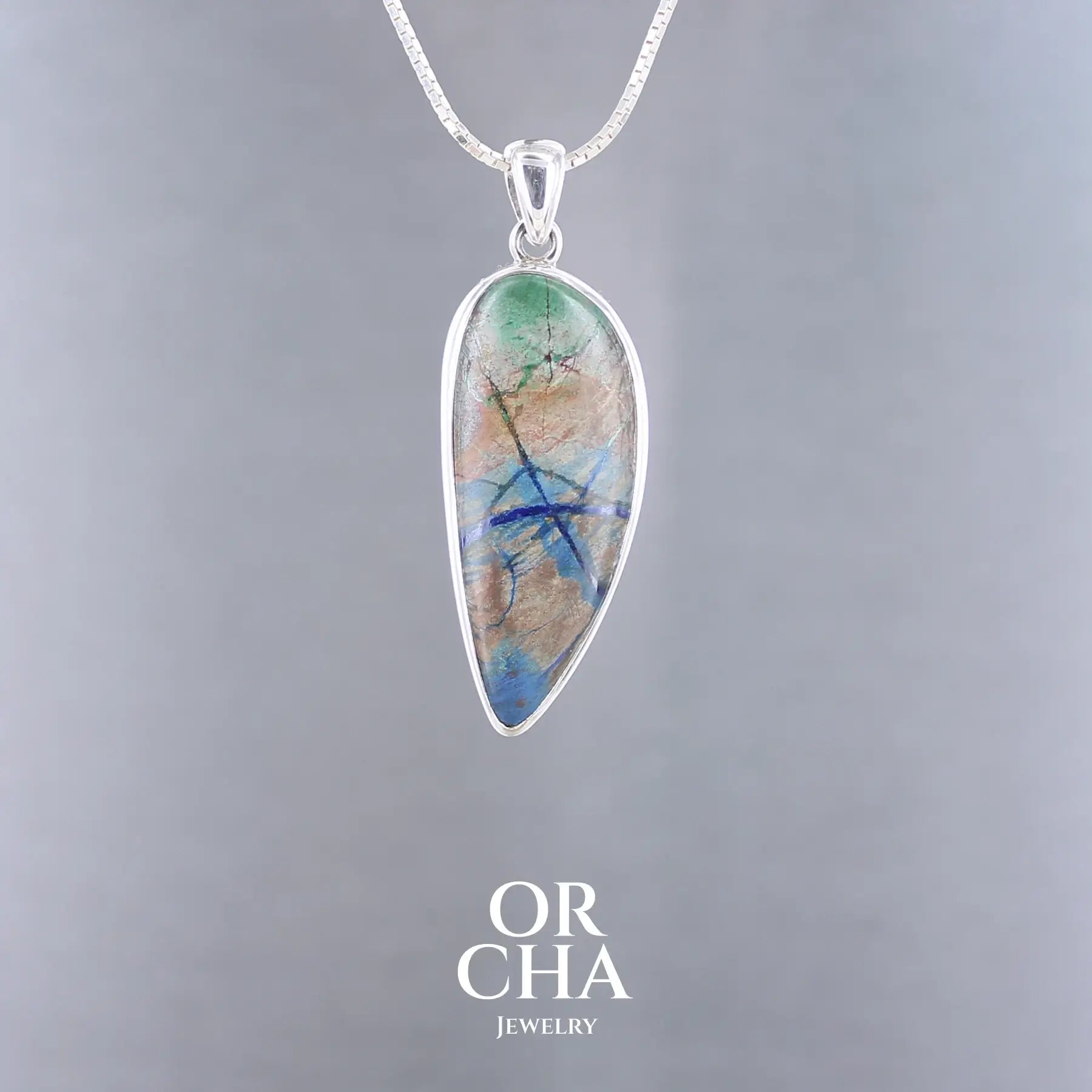 Pendentif en argent massif 925 avec azurite de Morenci, pierre naturelle aux reflets bleu intense, vert et cuivré, en forme de goutte allongée. Bijoux unique, éthique et durable présenté dans un coffret de notre marque, prêt à offrir. Livraison offerte, certificat d'authenticité, service client.