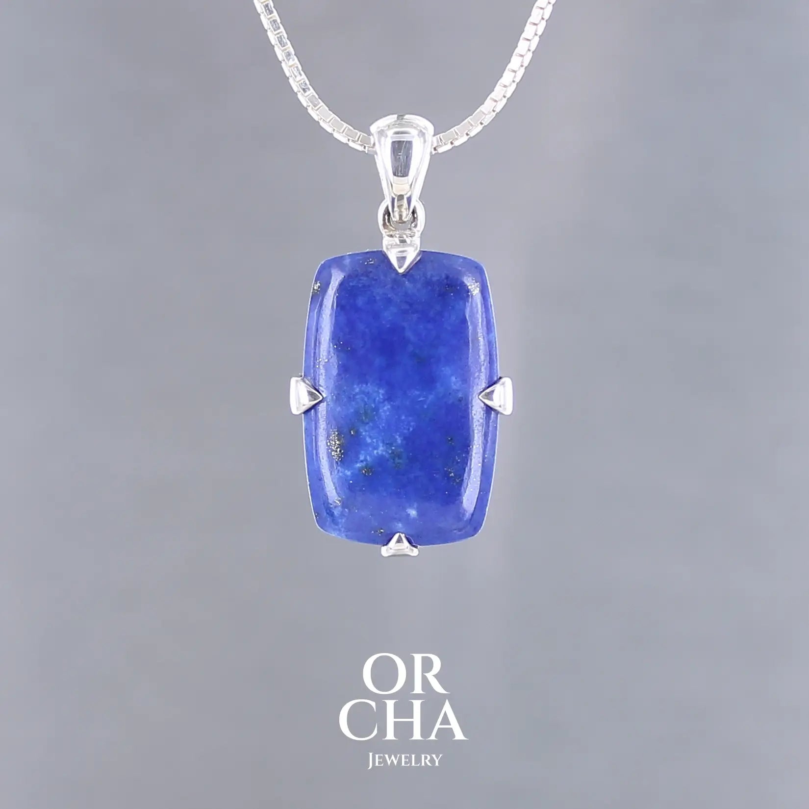 Pendentif rectangulaire en lapis lazuli bleu intense, serti de griffes épaisses en argent massif 925, monté sur une bélière élégante, bijou fait main. Bijoux unique, éthique et durable présenté dans un coffret de notre marque, prêt à offrir. Livraison offerte, certificat d'authenticité, service client.

