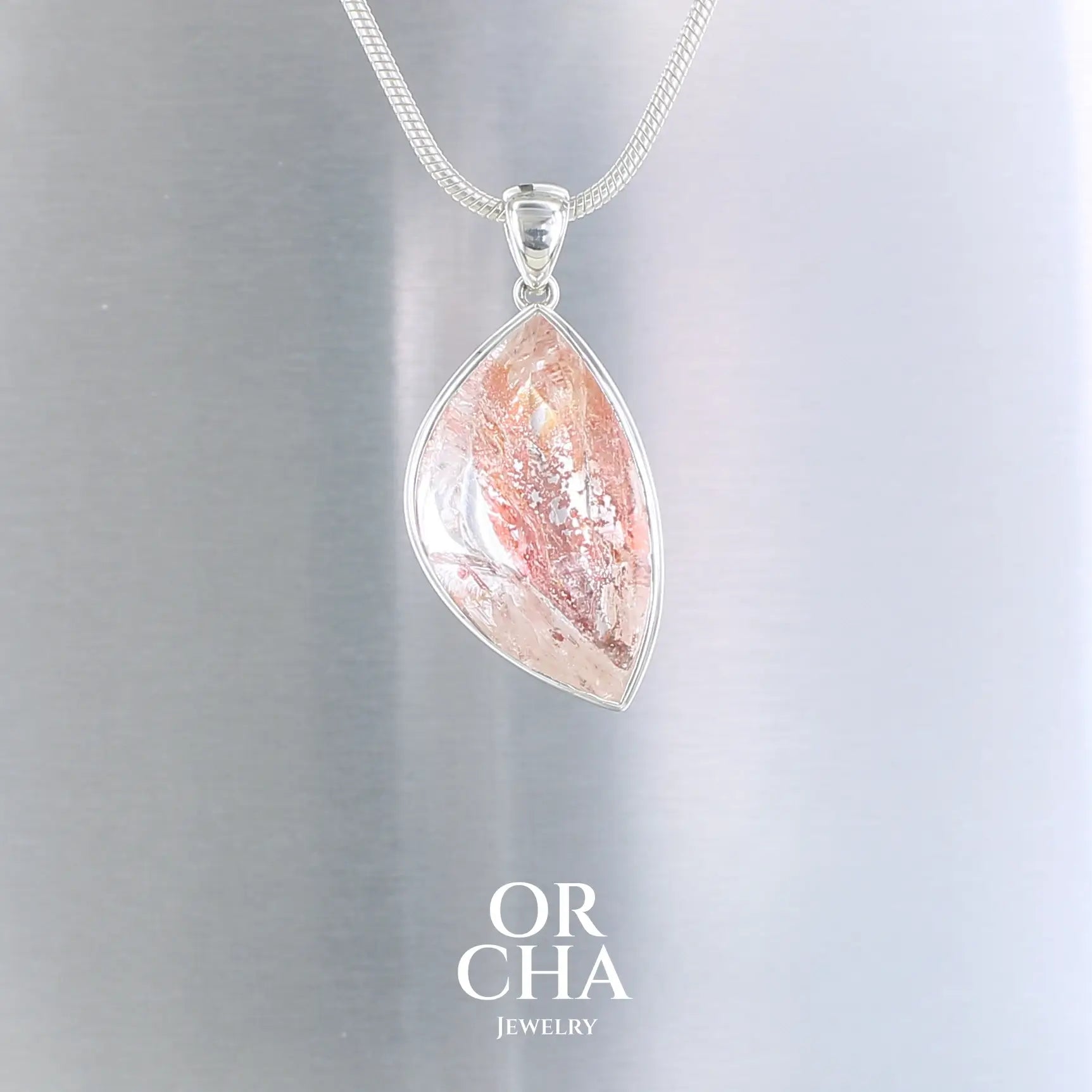 Pendentif pour femme en argent massif serti d'un Quartz Hématoïde transparent présentant de magnifiques inclusions de couleur orangées rouges. Bijoux unique, éthique et durable présenté dans un coffret de notre marque, prêt à offrir. Livraison offerte, certificat d'authenticité, service client.