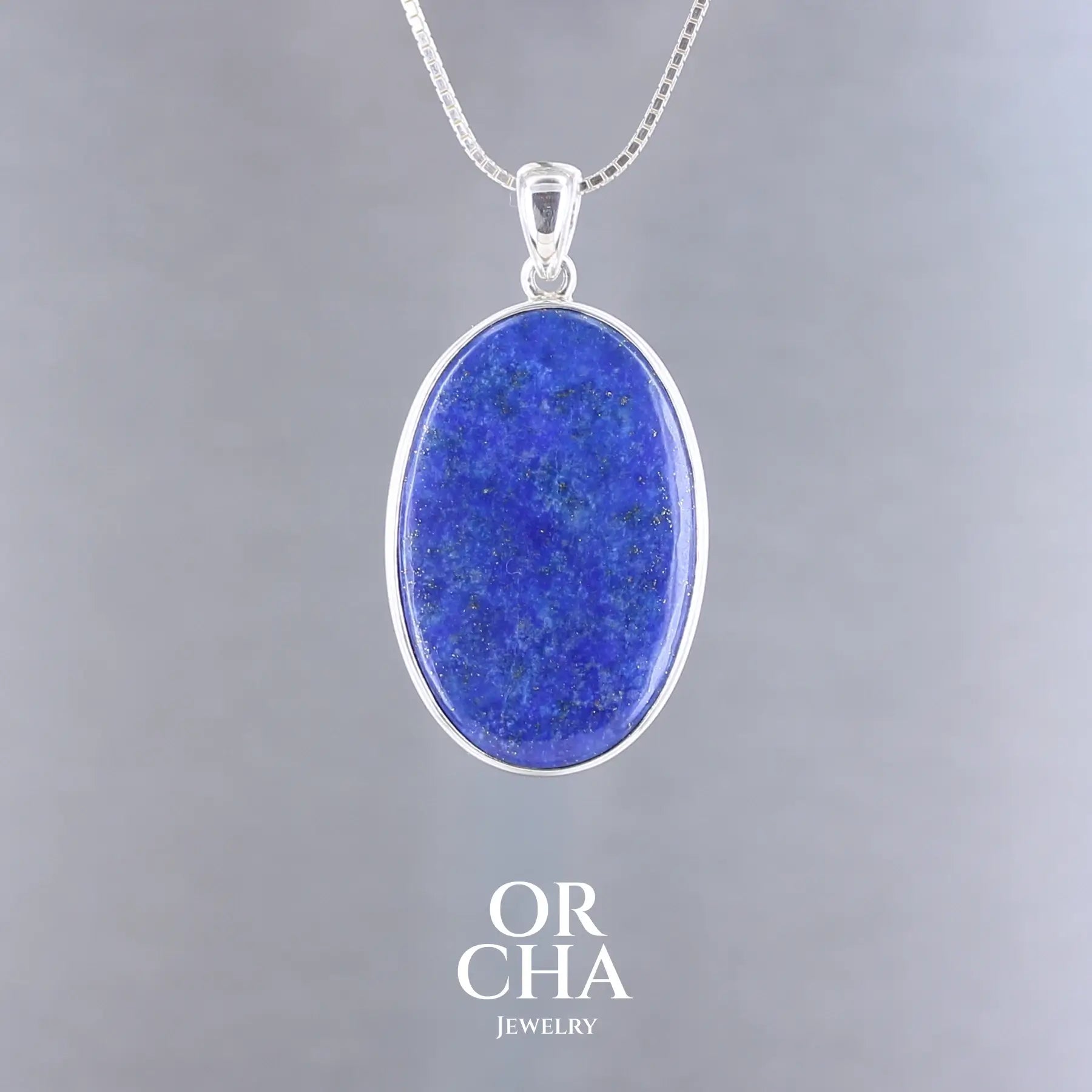 Pendentif ovale pour femme en argent massif serti d'un Lapis Lazuli. Pierre naturelle de couleur bleu nuit à inclusions de pyrite dorés, qualité  opaque. Bijoux unique, éthique et durable présenté dans un coffret de notre marque, prêt à offrir. Livraison offerte, certificat d'authenticité, service client.