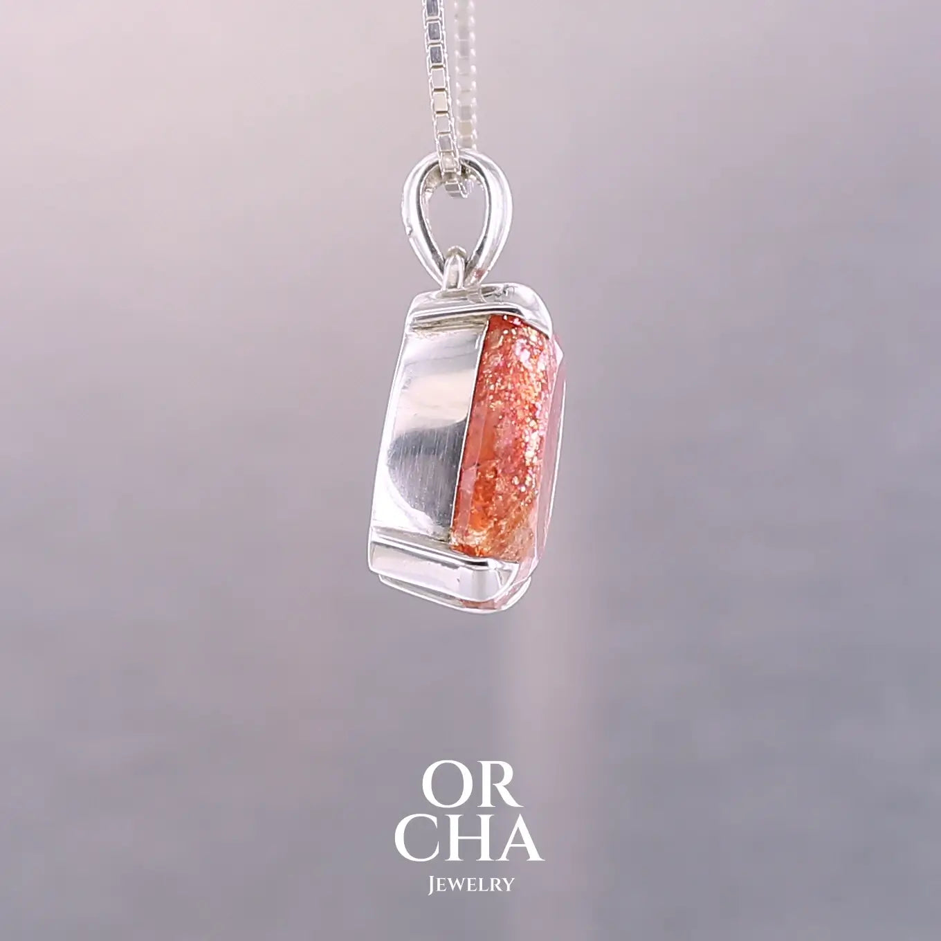 Pendentif en argent massif serti d'une magnifique pierre de soleil. Pierre facettée de forme ovale de qualité transparente. Pierre naturelle de couleur orange à scintillement doré et orangé. Bijoux unique, éthique et durable présenté dans un coffret de notre marque, prêt à offrir. Livraison offerte, certificat d'authenticité, service client.