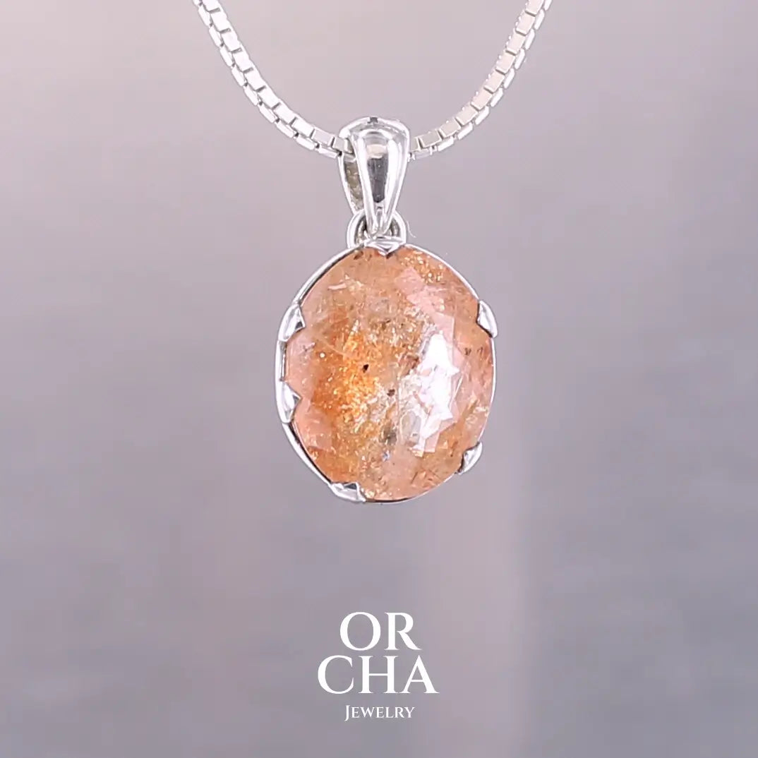 Pendentif en argent massif serti d'une magnifique pierre de soleil. Pierre facettée de forme ovale de qualité transparente. Pierre naturelle de couleur orange clair à scintillement doré et orangé. Bijoux unique, éthique et durable présenté dans un coffret de notre marque, prêt à offrir. Livraison offerte, certificat d'authenticité, service client.