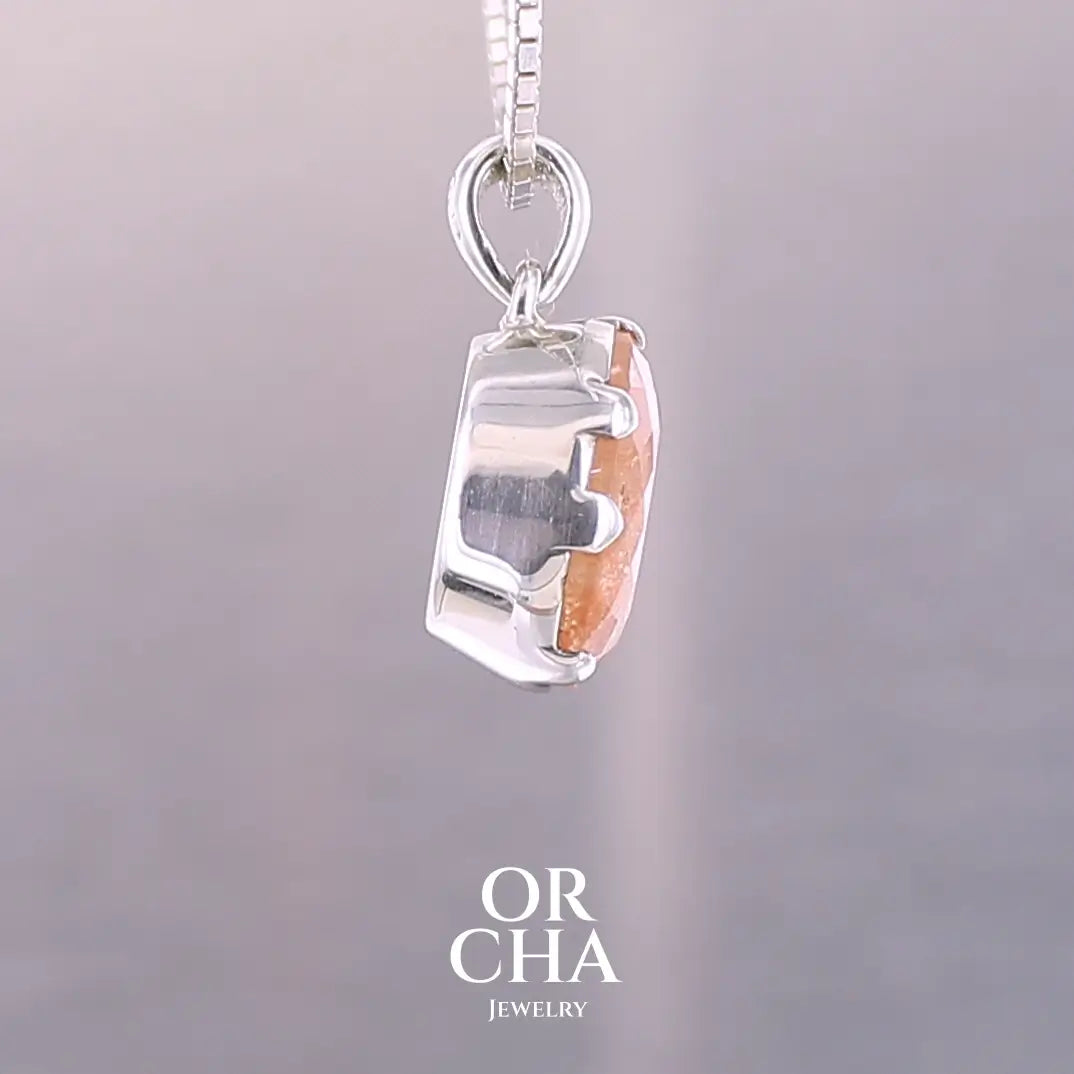 Pendentif en argent massif serti d'une magnifique pierre de soleil. Pierre facettée de forme ovale de qualité transparente. Pierre naturelle de couleur orange clair à scintillement doré et orangé. Bijoux unique, éthique et durable présenté dans un coffret de notre marque, prêt à offrir. Livraison offerte, certificat d'authenticité, service client.