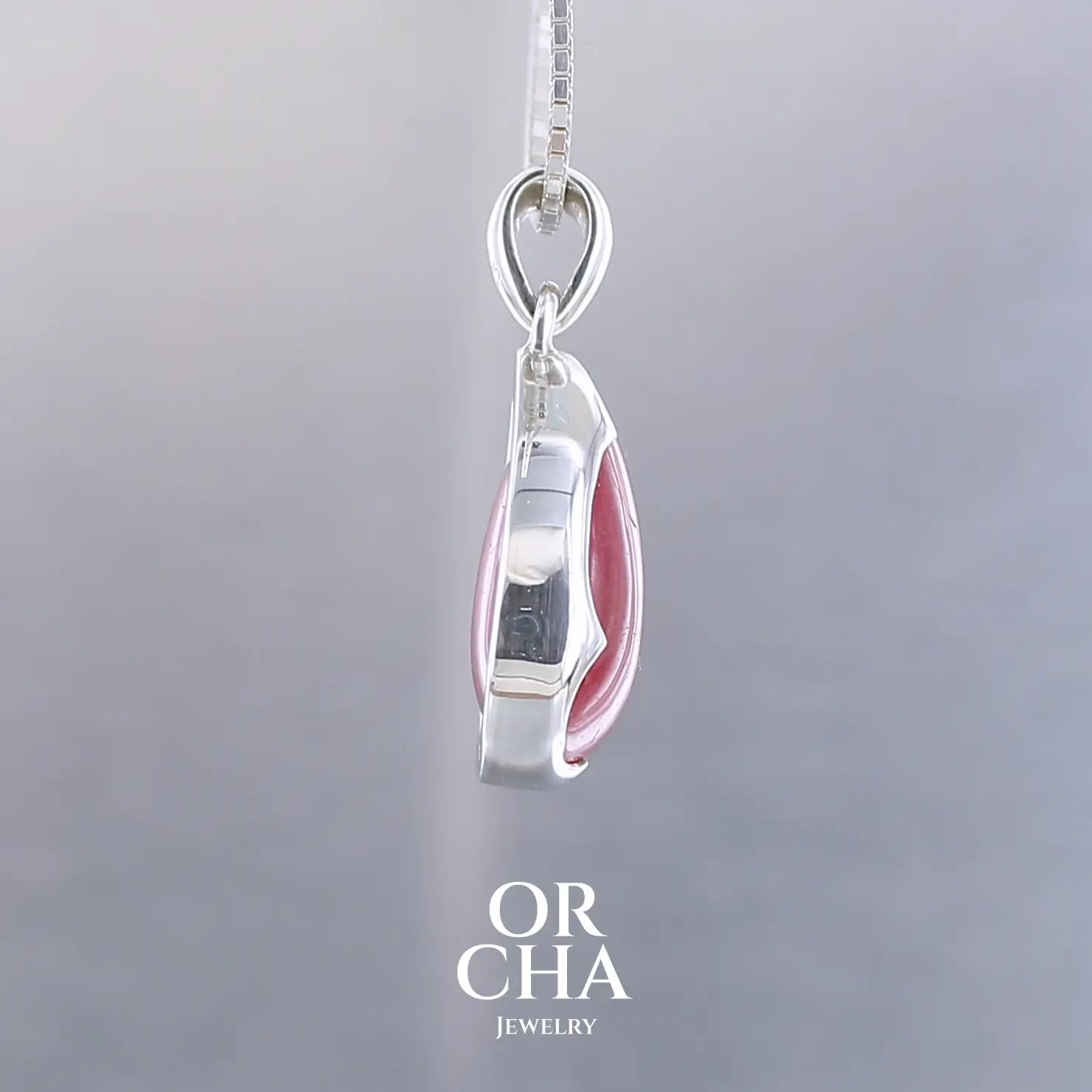 Pendentif pour femme en argent massif  serti d'une Rhodonite de belle qualité. Pierre de couleur rouge coquelicot, opaque à inclusions. Pierre naturelle, en forme de goutte, taillée en cabochon. Bijoux unique, éthique et durable présenté dans un coffret de notre marque, prêt à offrir. Livraison offerte, certificat d'authenticité, service client