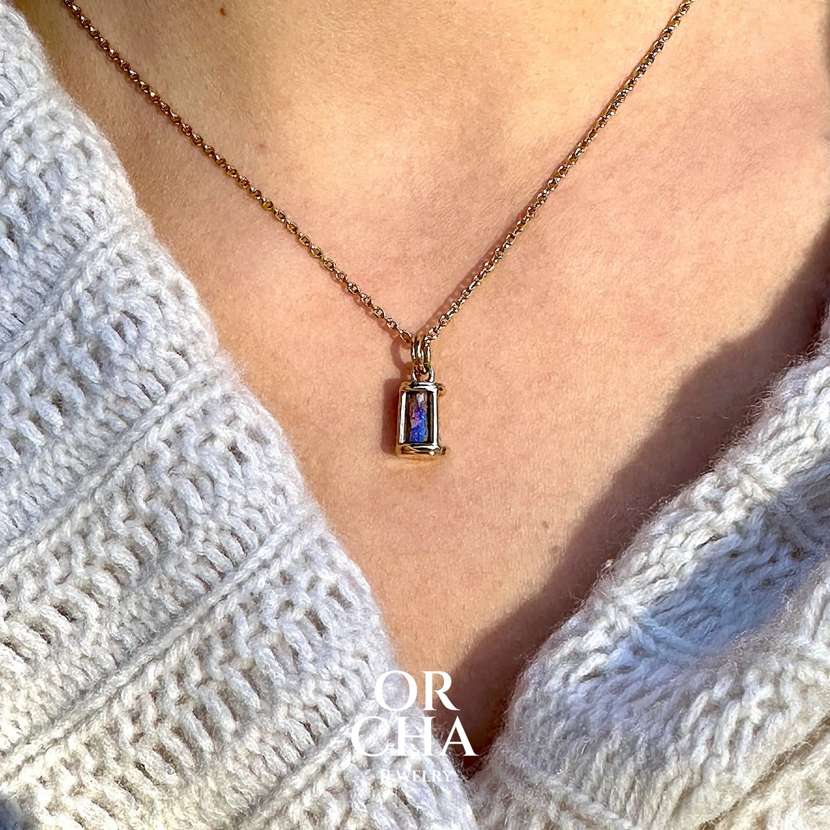 Pendentif pour femme en or jaune massif 14k serti d'une opale pipe aux feux  multicolores à dominantes bleu et violet. Specimen cylindrique, sertissage cage, opale rarement proposé en bijouterie. Bijou unique par par Orchajewelry
