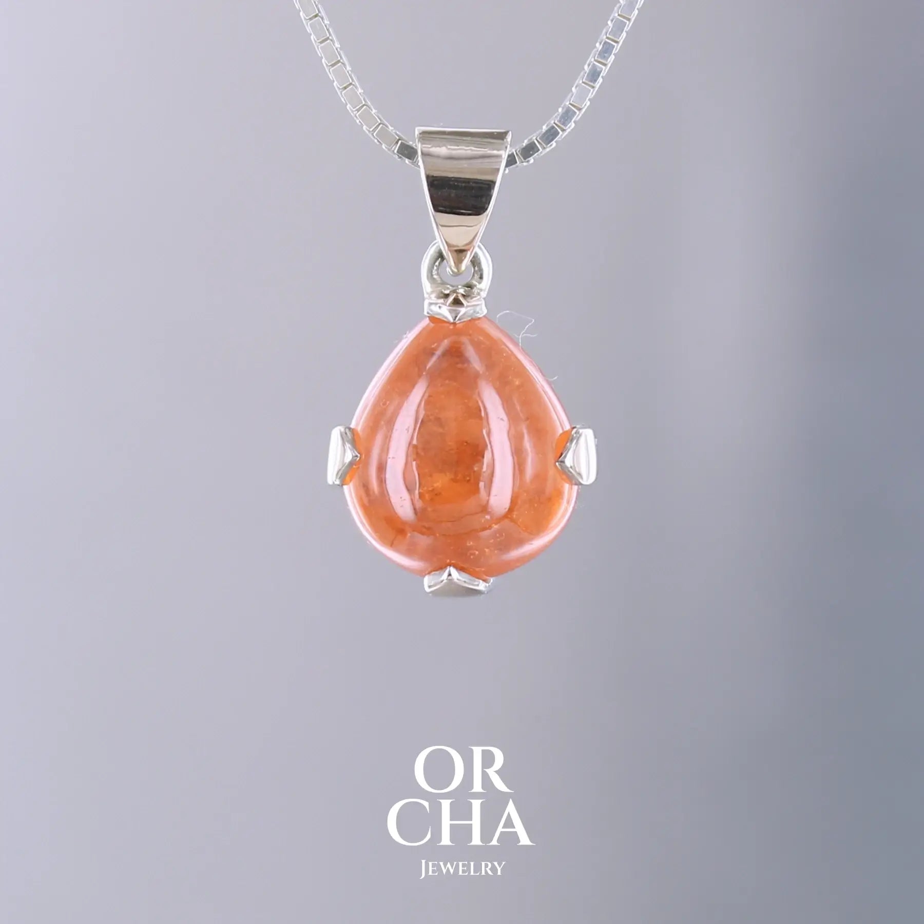 Pendentif en or jaune massif 9k et argent massif serti d'un grenat spessartite de 11,5 carats.  Cabochon en forme de goutte de couleur orange intense dit "Fanta color". Pierre transparente à inclusions. Bijoux unique, éthique et durable présenté dans un coffret de notre marque, prêt à offrir. Livraison offerte, certificat d'authenticité, service client.
