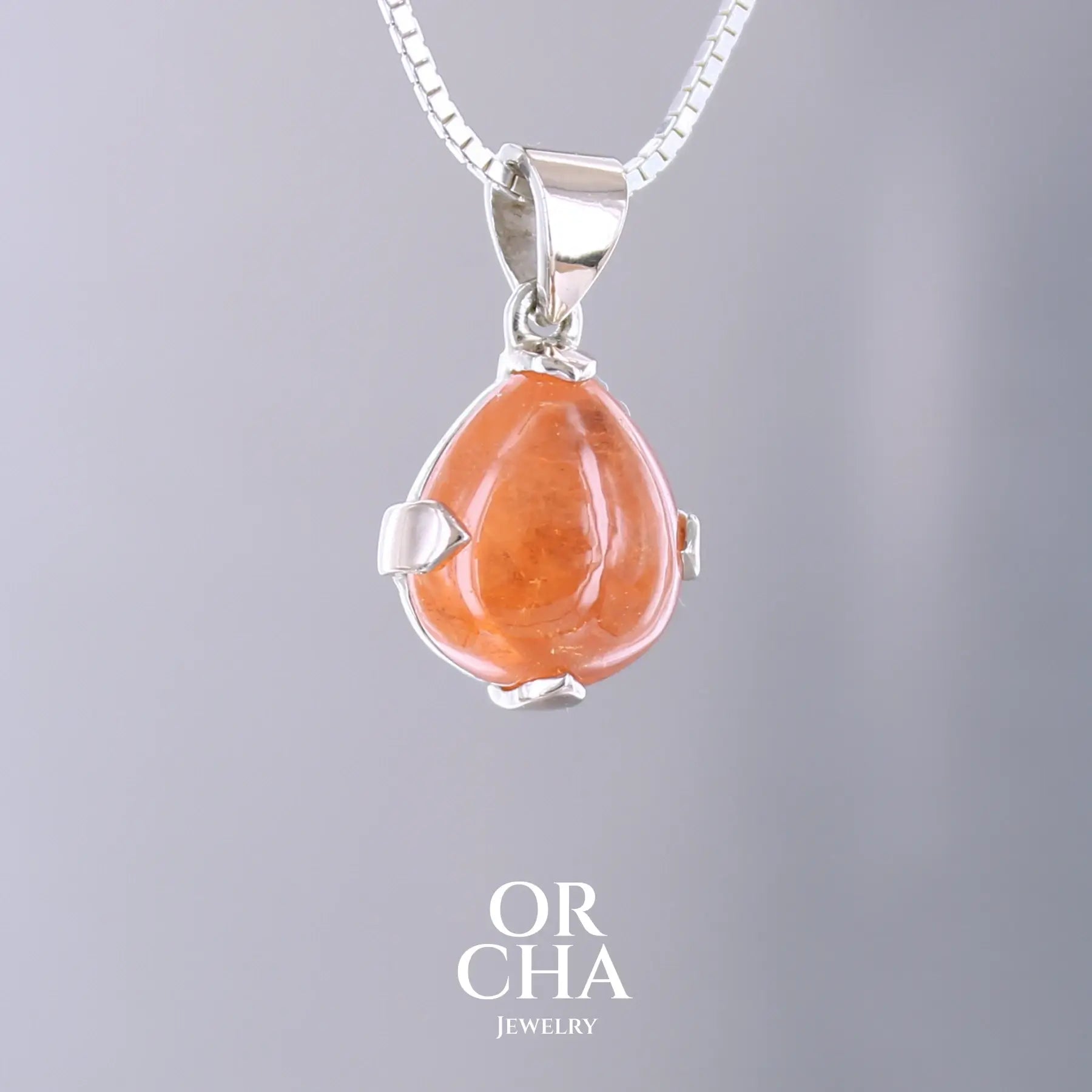 Pendentif en or jaune massif 9k et argent massif serti d'un grenat spessartite de 11,5 carats.  Cabochon en forme de goutte de couleur orange intense dit "Fanta color". Pierre transparente à inclusions. Bijoux unique, éthique et durable présenté dans un coffret de notre marque, prêt à offrir. Livraison offerte, certificat d'authenticité, service client.