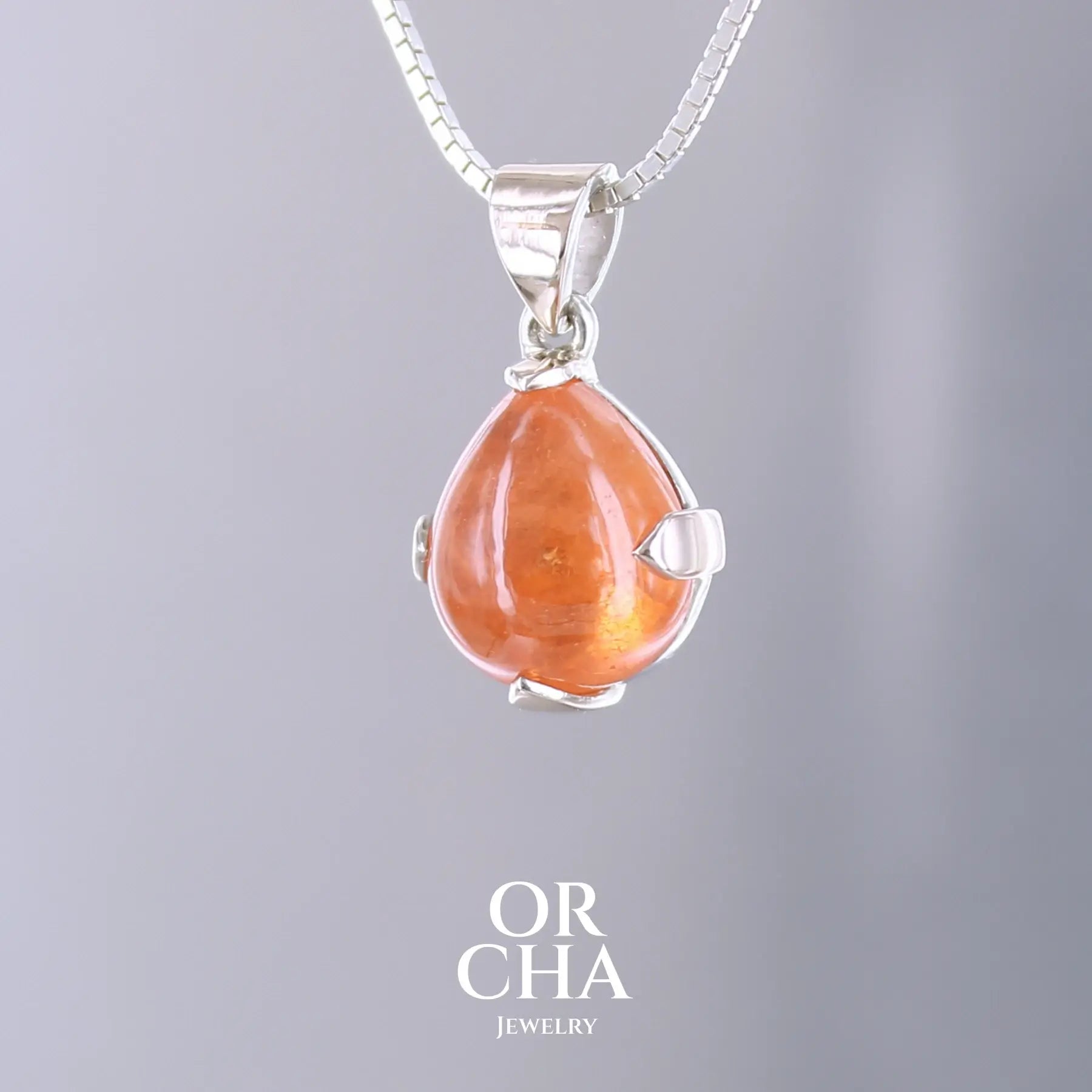 Pendentif en or jaune massif 9k et argent massif serti d'un grenat spessartite de 11,5 carats.  Cabochon en forme de goutte de couleur orange intense dit "Fanta color". Pierre transparente à inclusions. Bijoux unique, éthique et durable présenté dans un coffret de notre marque, prêt à offrir. Livraison offerte, certificat d'authenticité, service client.