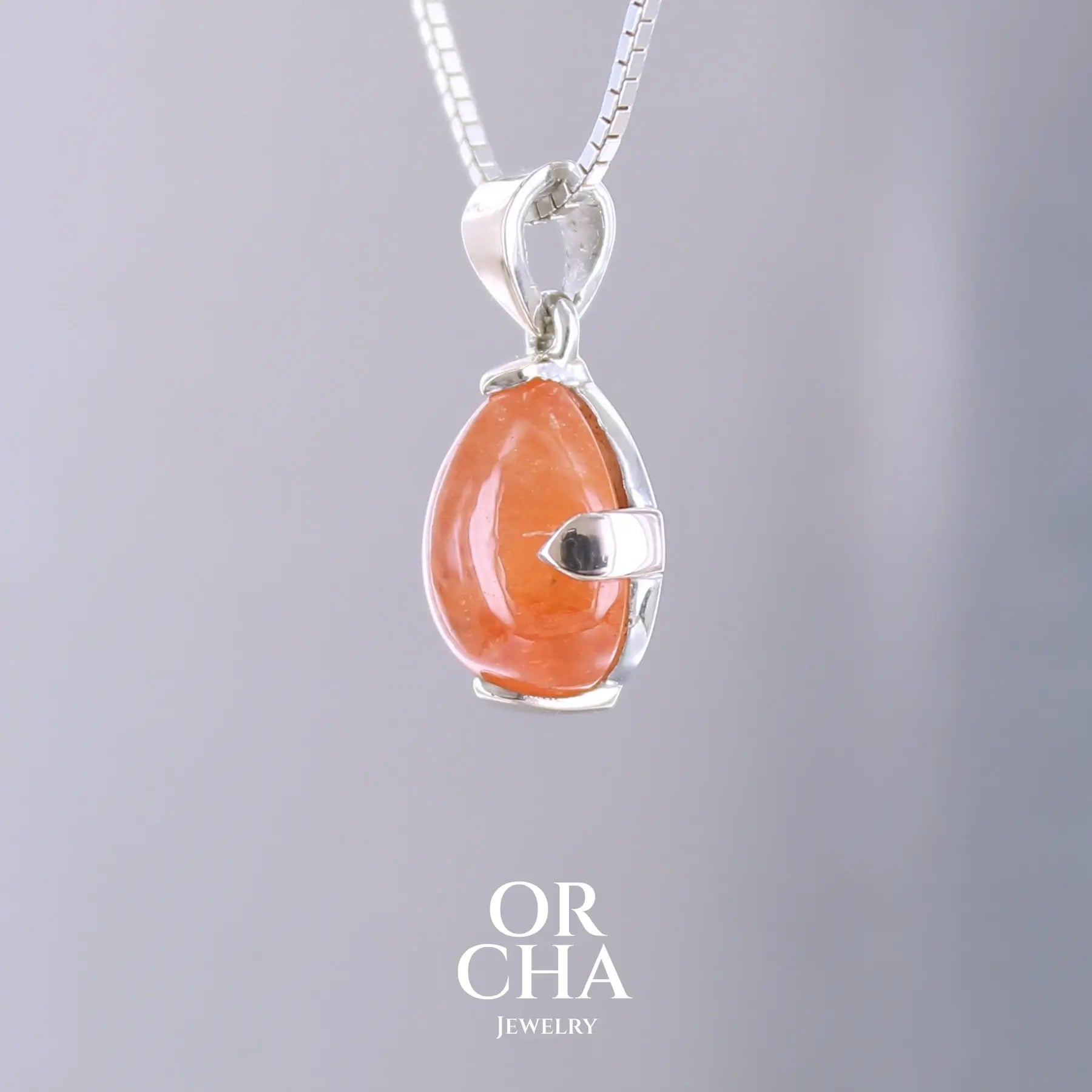 Pendentif en or jaune massif 9k et argent massif serti d'un grenat spessartite de 11,5 carats.  Cabochon en forme de goutte de couleur orange intense dit "Fanta color". Pierre transparente à inclusions. Bijoux unique, éthique et durable présenté dans un coffret de notre marque, prêt à offrir. Livraison offerte, certificat d'authenticité, service client.