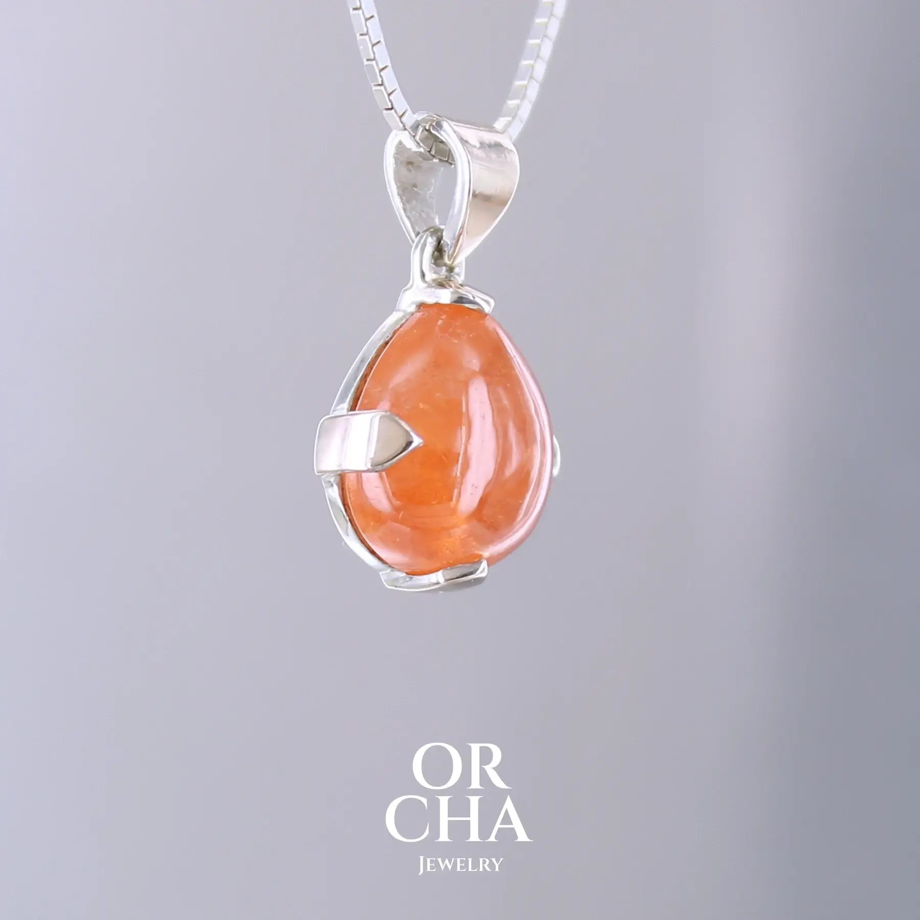 Pendentif en or jaune massif 9k et argent massif serti d'un grenat spessartite de 11,5 carats.  Cabochon en forme de goutte de couleur orange intense dit "Fanta color". Pierre transparente à inclusions. Bijoux unique, éthique et durable présenté dans un coffret de notre marque, prêt à offrir. Livraison offerte, certificat d'authenticité, service client.