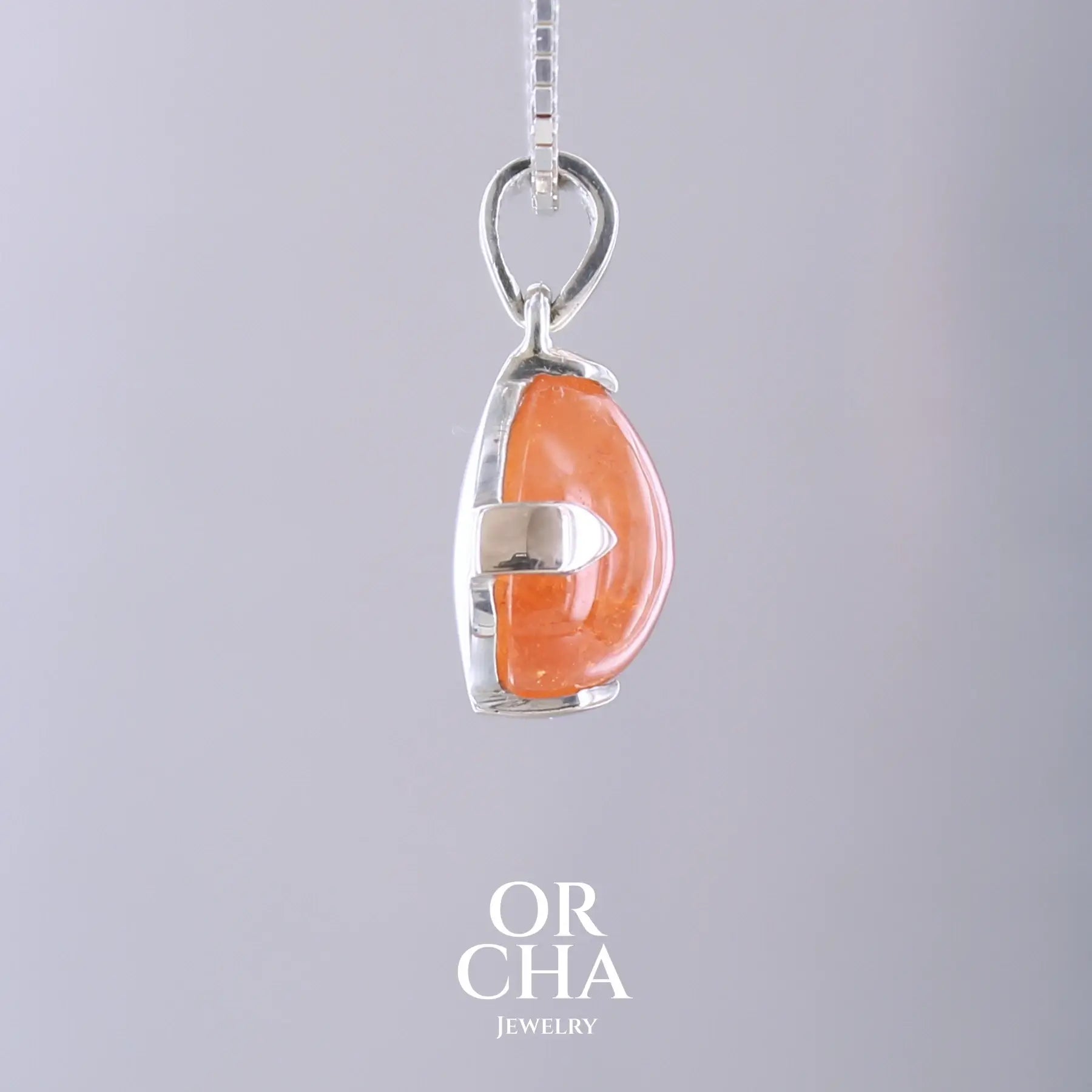 Pendentif en or jaune massif 9k et argent massif serti d'un grenat spessartite de 11,5 carats.  Cabochon en forme de goutte de couleur orange intense dit "Fanta color". Pierre transparente à inclusions. Bijoux unique, éthique et durable présenté dans un coffret de notre marque, prêt à offrir. Livraison offerte, certificat d'authenticité, service client.
