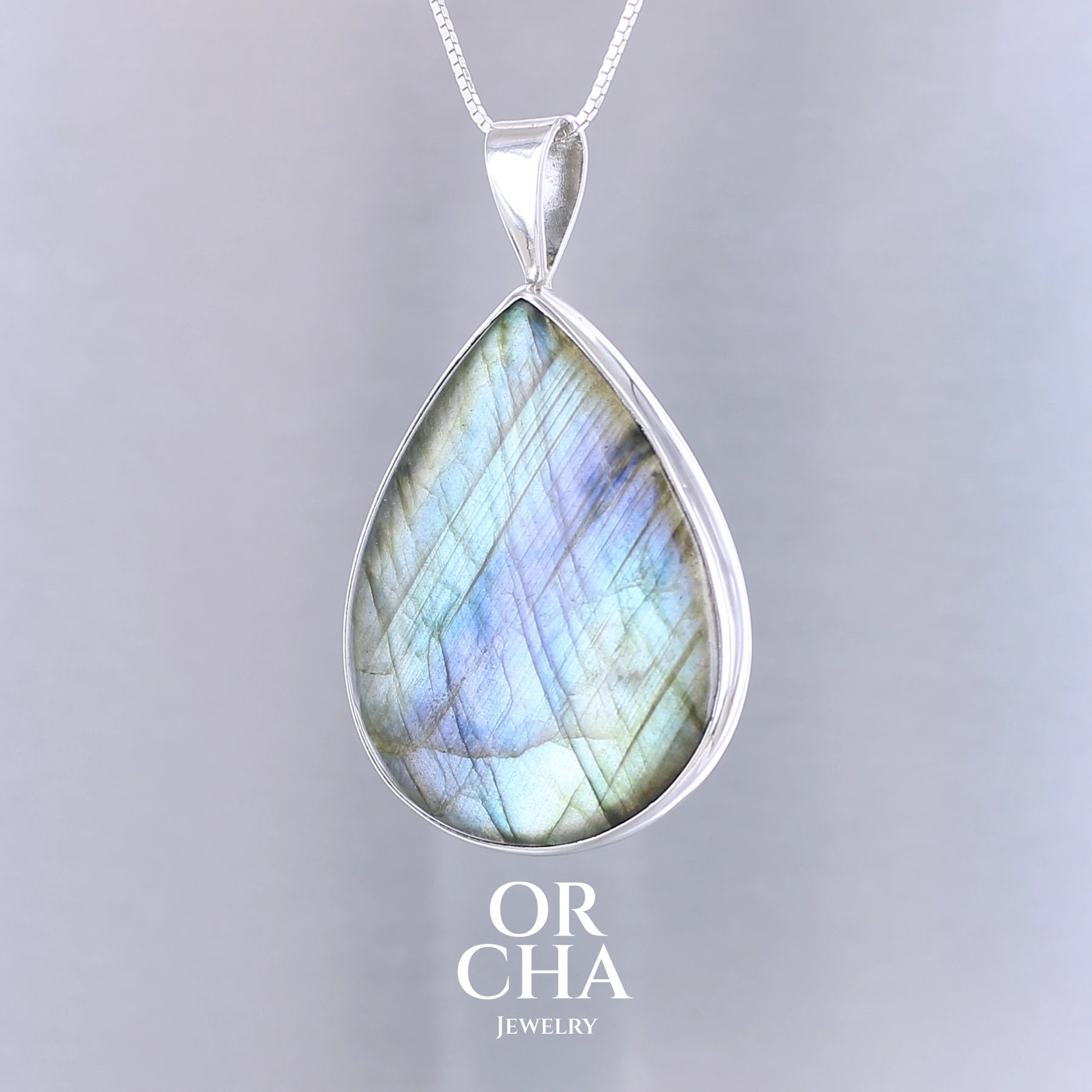 Pendentif pour femme en argent massif sertie d'une labradorite aux reflets bleus, bronzes et or selon la lumière. Pierre facettée naturelle translucide présentant des inclusions fréquents sur ce type de pierre. Bijoux unique, éthique et durable présenté dans un coffret de notre marque, prêt à offrir. Livraison offerte, certificat d'authenticité, service client.
