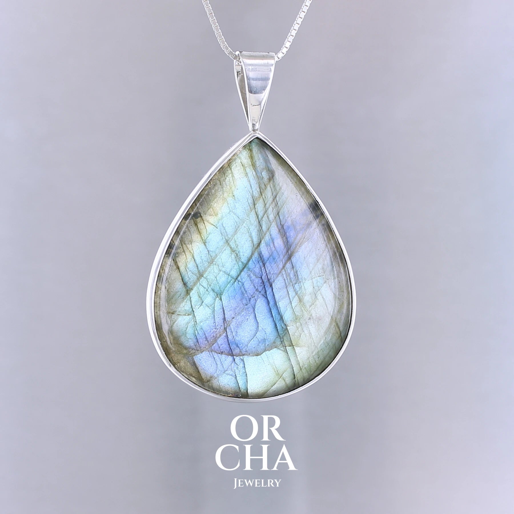 Pendentif pour femme en argent massif sertie d'une labradorite aux reflets bleus, bronzes et or selon la lumière. Pierre facettée naturelle translucide présentant des inclusions fréquents sur ce type de pierre. Bijoux unique, éthique et durable présenté dans un coffret de notre marque, prêt à offrir. Livraison offerte, certificat d'authenticité, service client.
