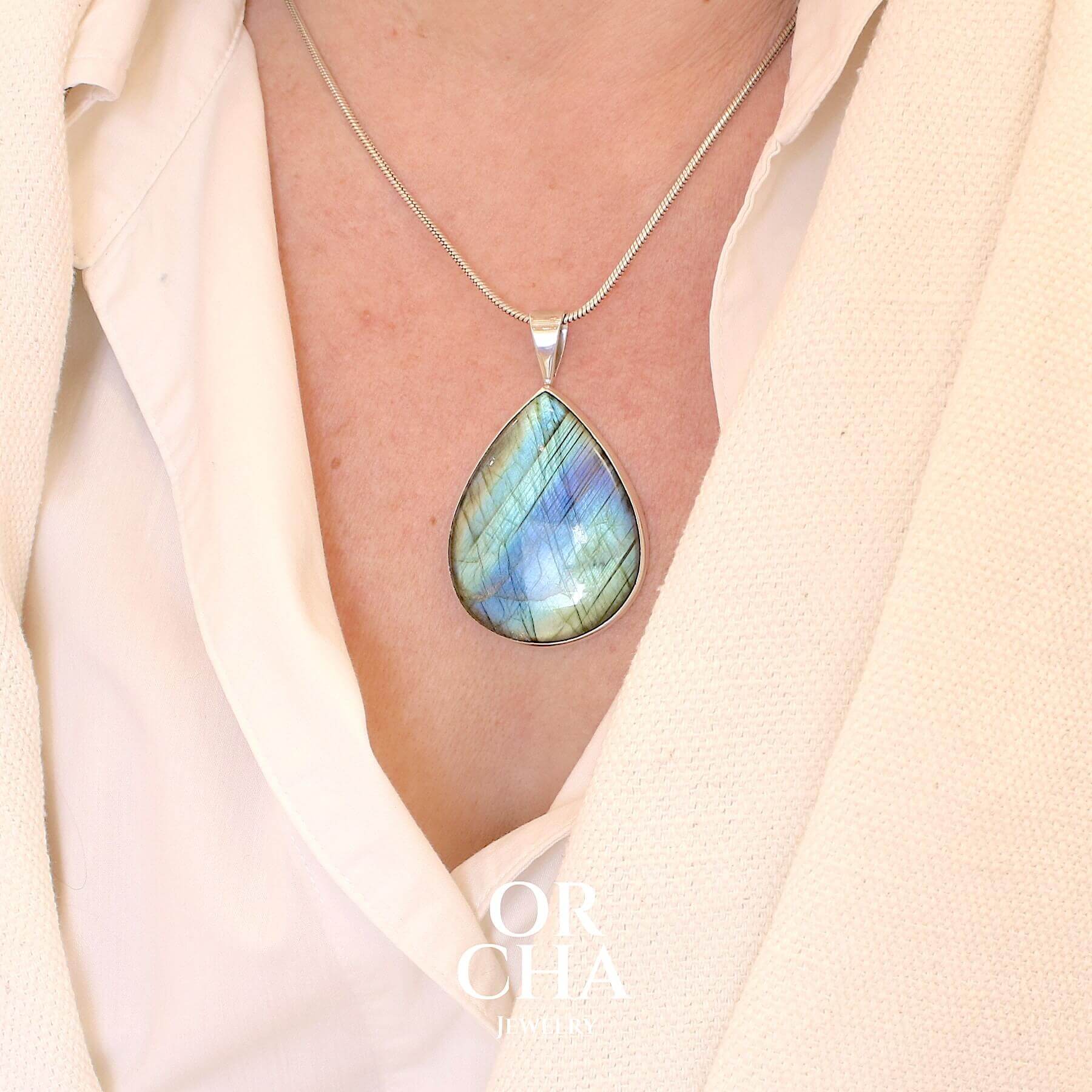 Pendentif pour femme en argent massif sertie d'une labradorite aux reflets bleus, bronzes et or selon la lumière. Pierre facettée naturelle translucide présentant des inclusions fréquents sur ce type de pierre. Bijoux unique, éthique et durable présenté dans un coffret de notre marque, prêt à offrir. Livraison offerte, certificat d'authenticité, service client.
