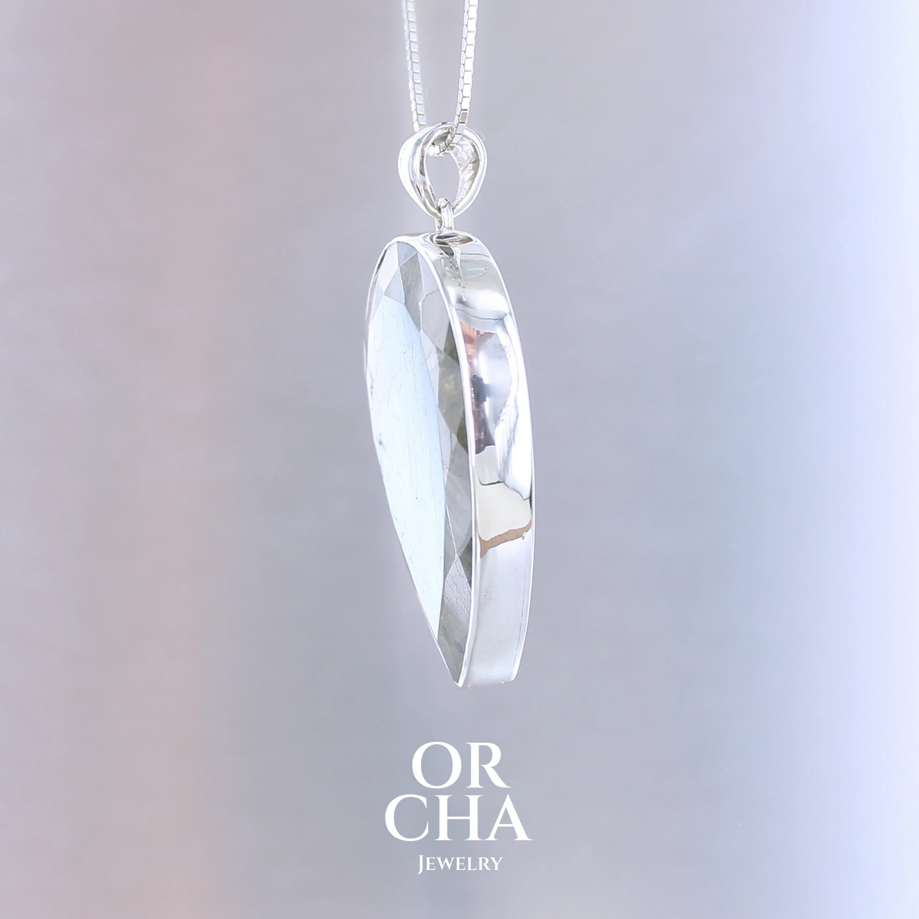 Pendentif pour femme en argent massif sertie d'une labradorite aux reflets bleus et bronze selon la lumière. Pierre facettée naturelle translucide présentant des inclusions fréquents sur ce type de pierre. Bijoux unique, éthique et durable présenté dans un coffret de notre marque, prêt à offrir. Livraison offerte, certificat d'authenticité, service client.